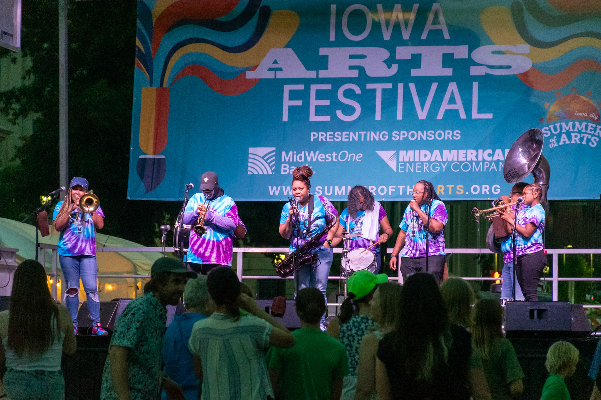 IOWA CITY, IOWA – JUNE 6, 2025: The Original Pinettes Brass Band commands the stage at the Iowa Arts Festival as the crowd dances below. With horns blazing and vocals soaring, the all-female ensemble lit up the night with their unmistakable New Orleans sound.