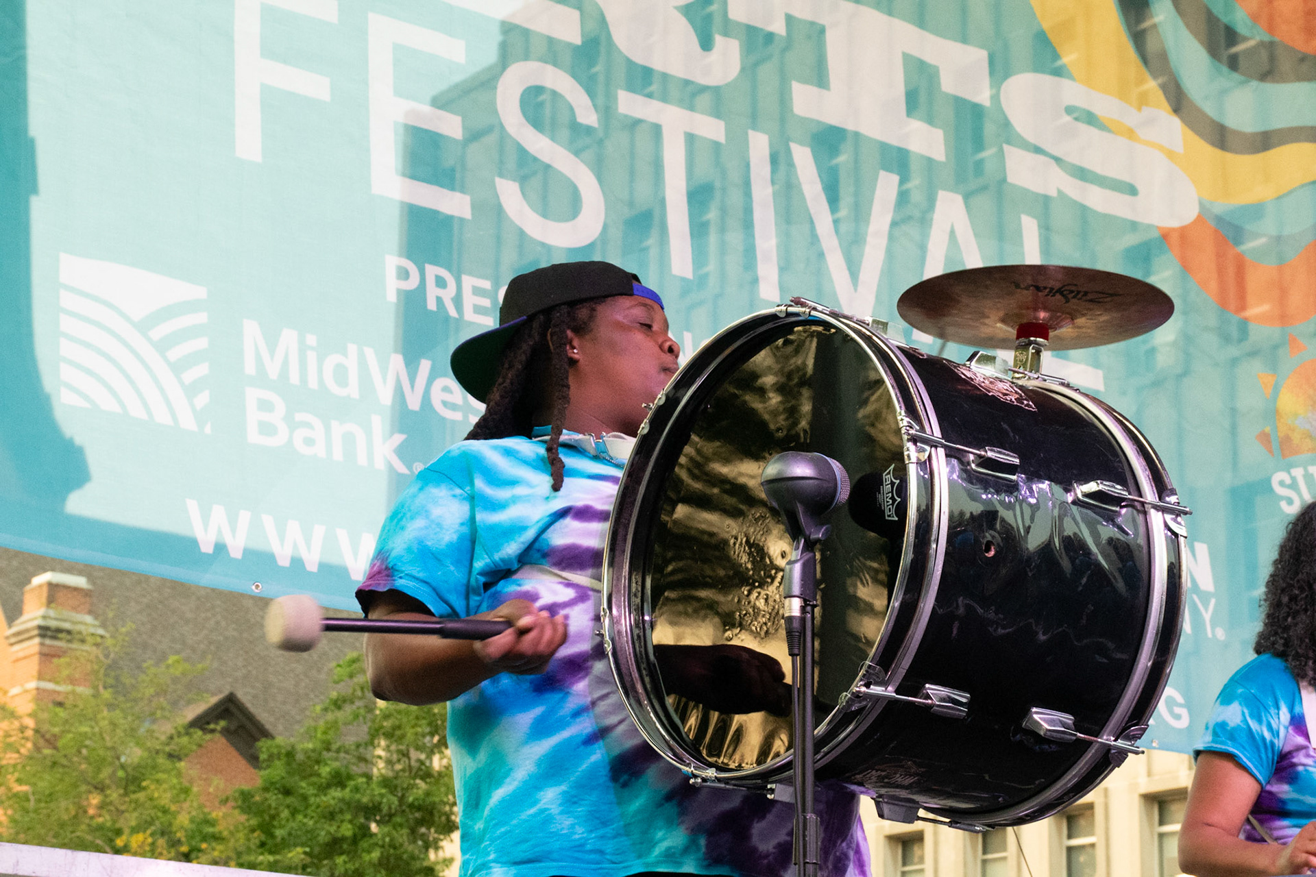 IOWA CITY, IOWA – JUNE 6, 2025: Justina Sylvester locks in the tempo on bass drum as The Original Pinettes Brass Band brings the streets of Iowa City to life. Her steady cadence kept the crowd moving and the music flowing strong.