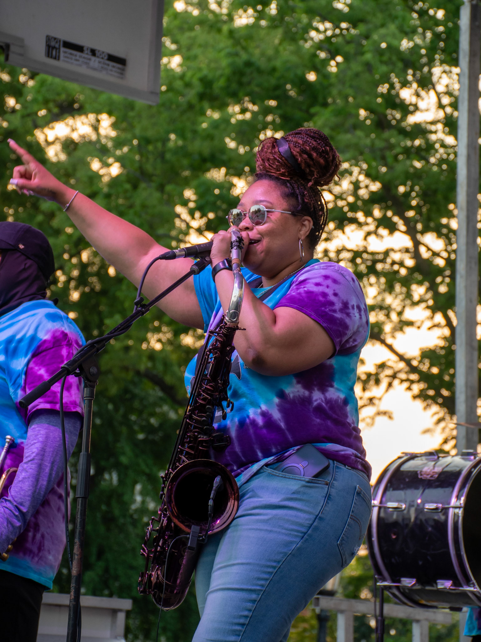 IOWA CITY, IOWA – JUNE 6, 2025: Natasha Harris commands the stage with a tenor saxophone in hand, leading the crowd with vocals and flair at the Iowa Arts Festival. Her vibrant energy and smooth delivery embodied the bold spirit of The Original Pinettes Brass Band.