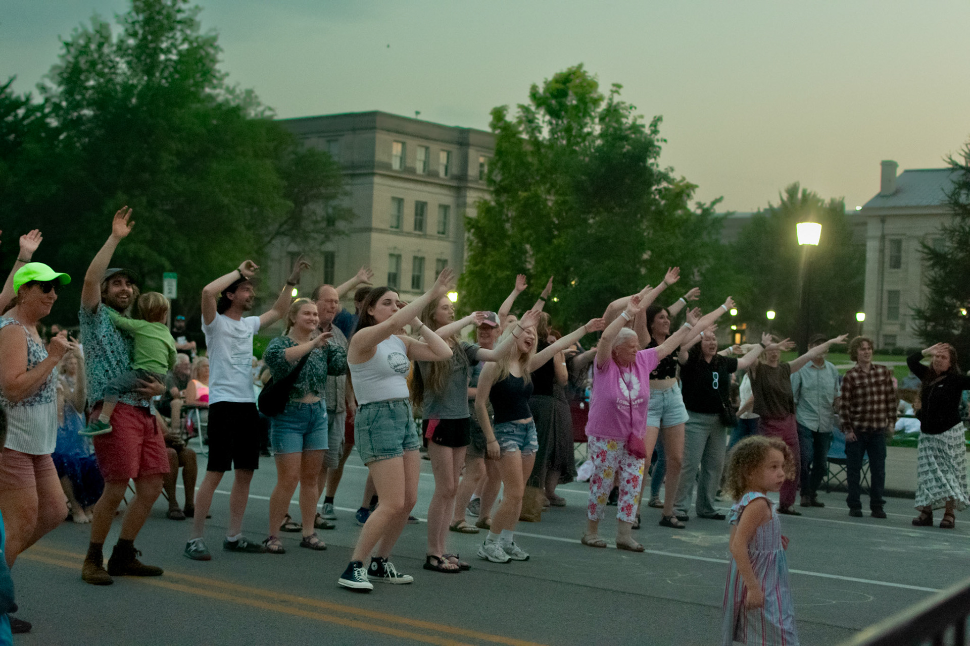 IOWA CITY, IOWA – JUNE 6, 2025: Festivalgoers of all ages dance and sing along during The Original Pinettes Brass Band’s performance at the Iowa Arts Festival. The crowd filled Clinton Street with energy, joy, and movement as the sun began to set.