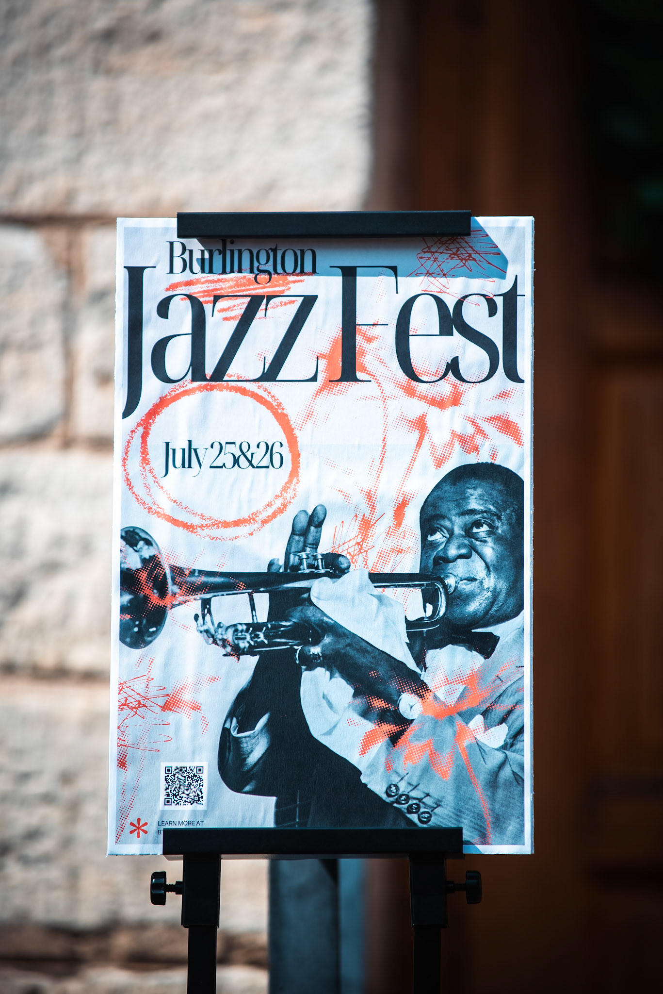 A Burlington Jazz Festival poster featuring jazz legend Louis Armstrong, who performed in Burlington decades ago, connects the city’s past to its present celebration of jazz on July 25–26, 2025.