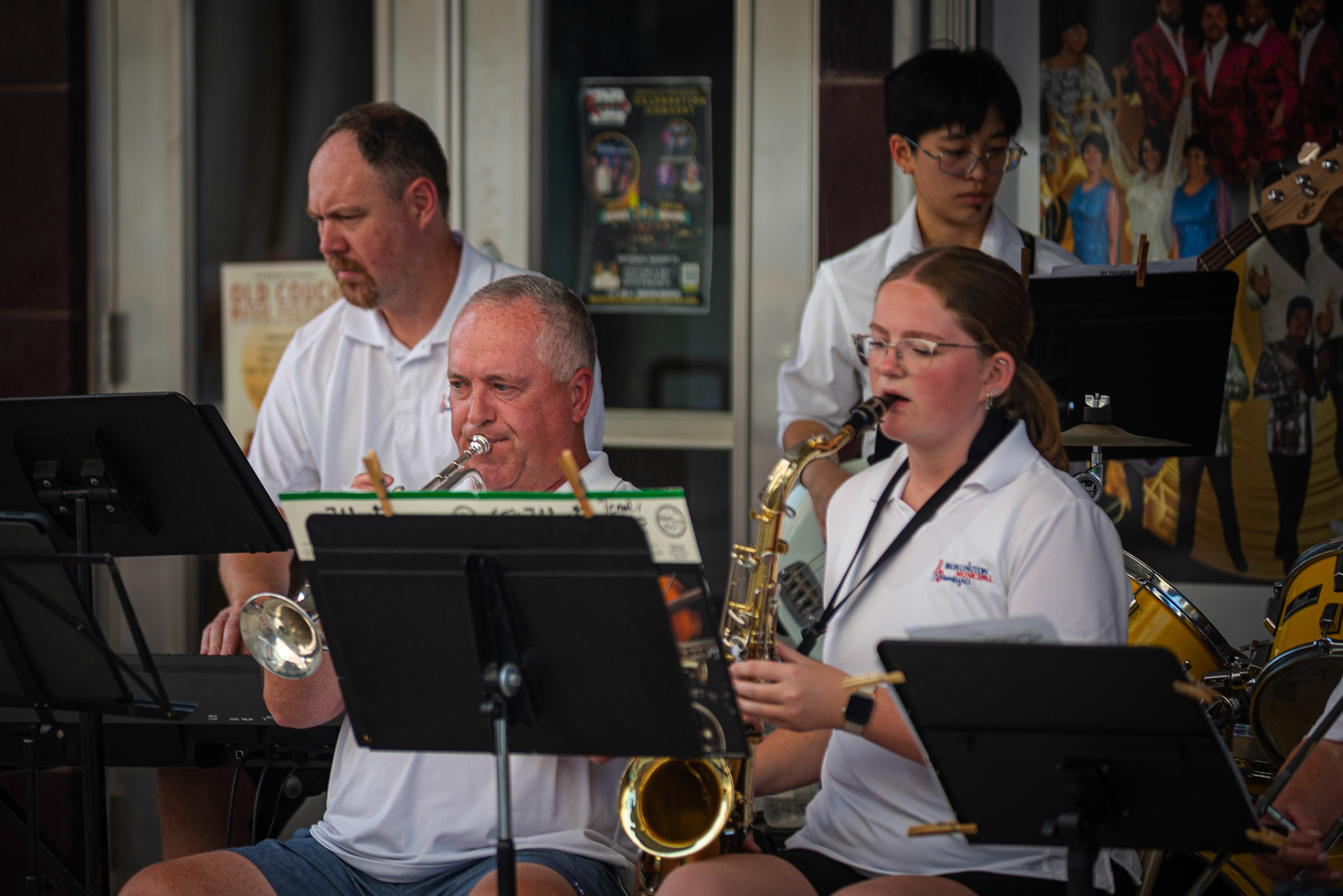 Members of the Burlington Municipal Band perform outside the Capitol Theater, featuring a multi-generational ensemble of musicians blending brass, winds, and rhythm. July 26, 2025