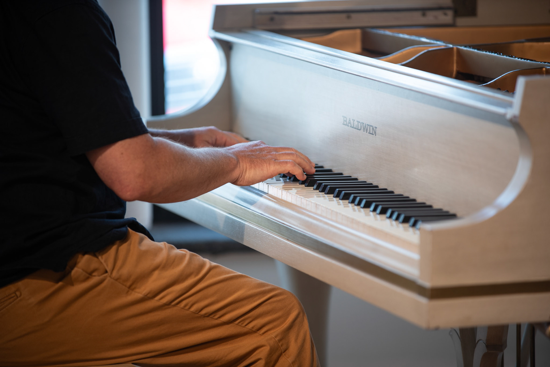 Close-up of pianist Matthew Fries' hands on the Baldwin grand piano during his solo performance at the Burlington Art Center on July 26, 2025.
