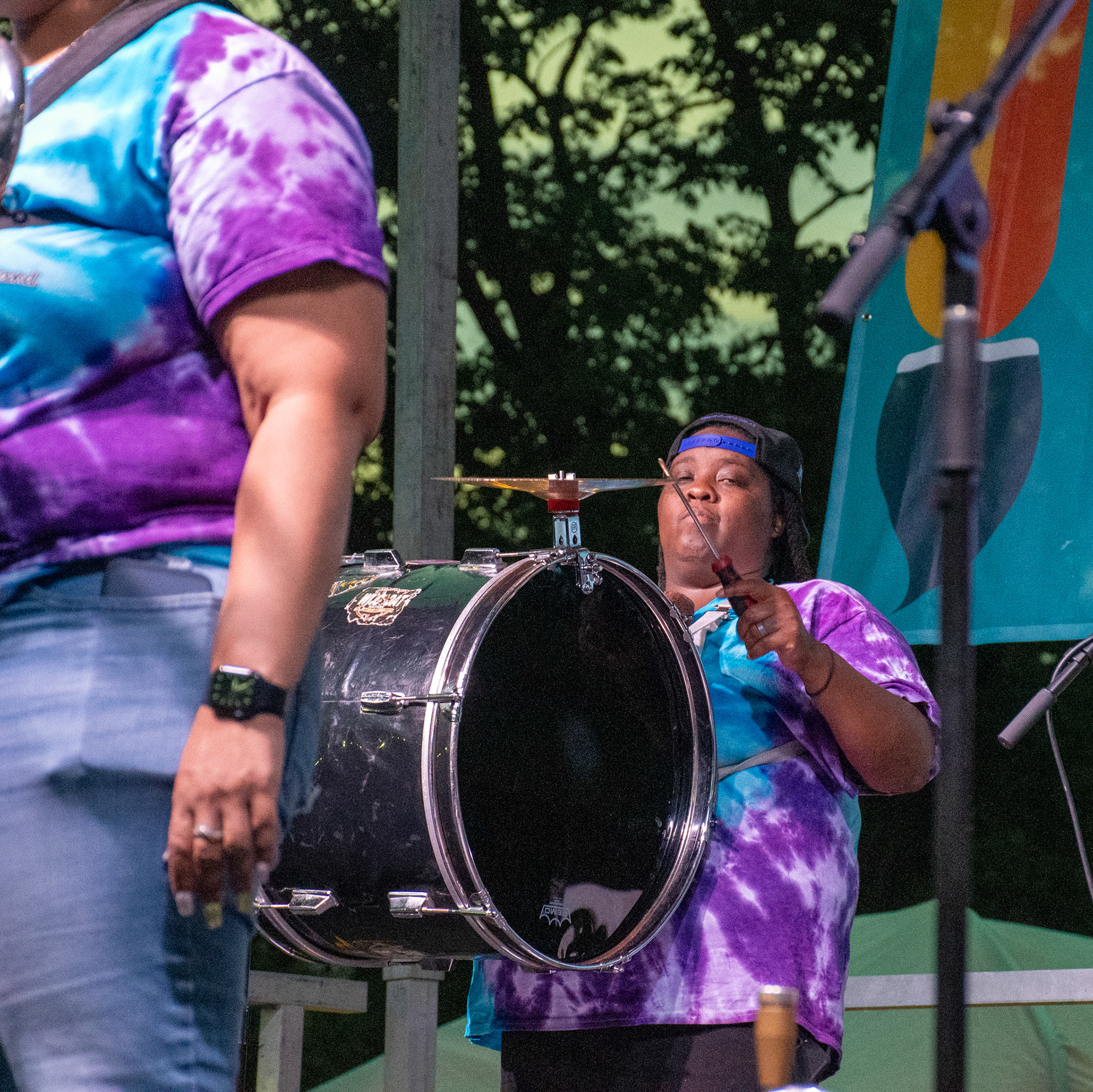IOWA CITY, IOWA – JUNE 6, 2025: Justina Sylvester keeps time with intensity on bass drum as The Original Pinettes Brass Band powers through their Iowa Arts Festival set. Her unwavering pulse anchored the band’s rich, rhythmic backbone.