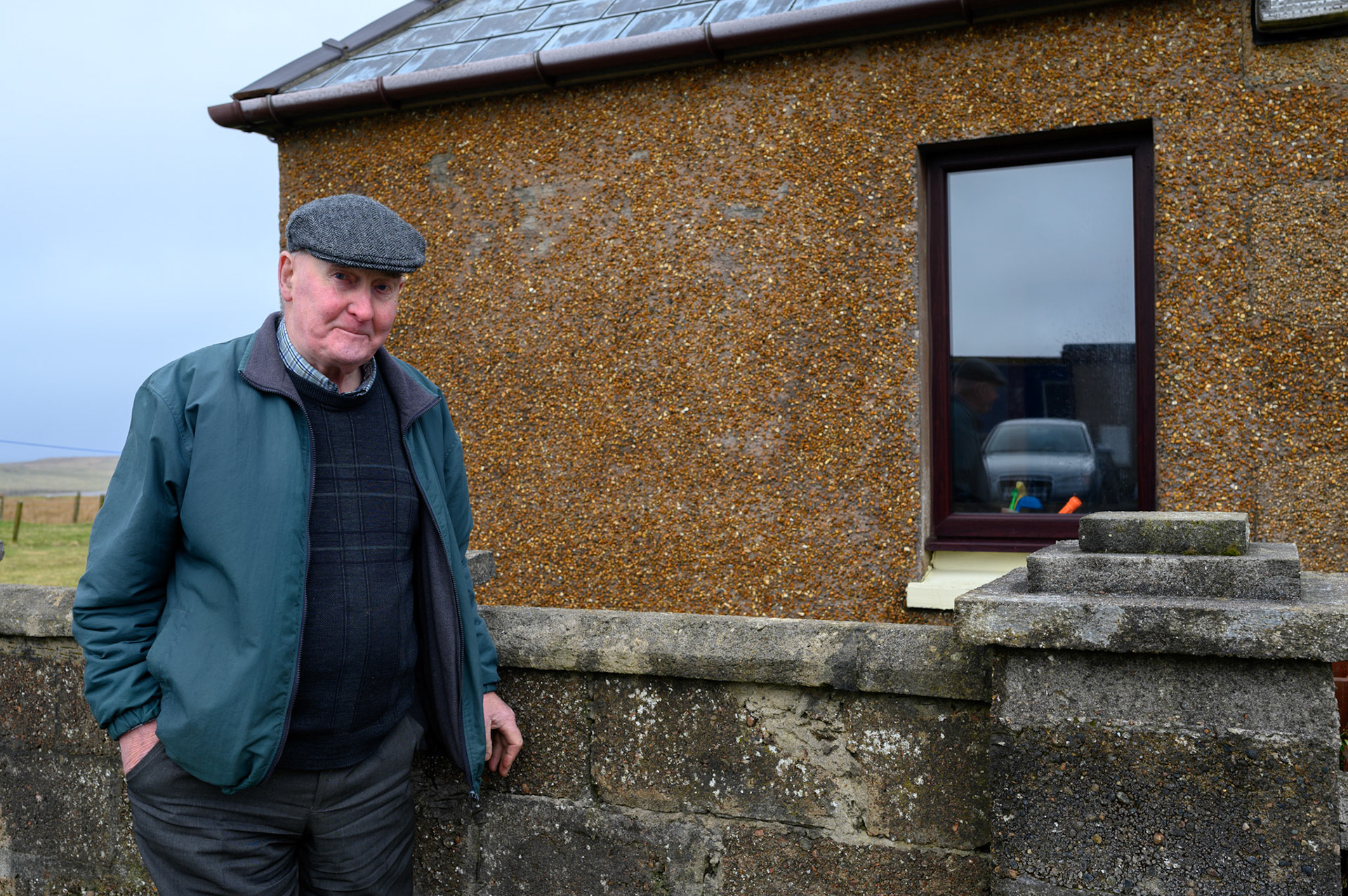 Robert Morrison made the bricks in this wall and his brother's house behind. The bricks are made from shingle off the nearby beach mixed with cement. The mix is formed in a manual press and dried on teh ground to make the bricks.