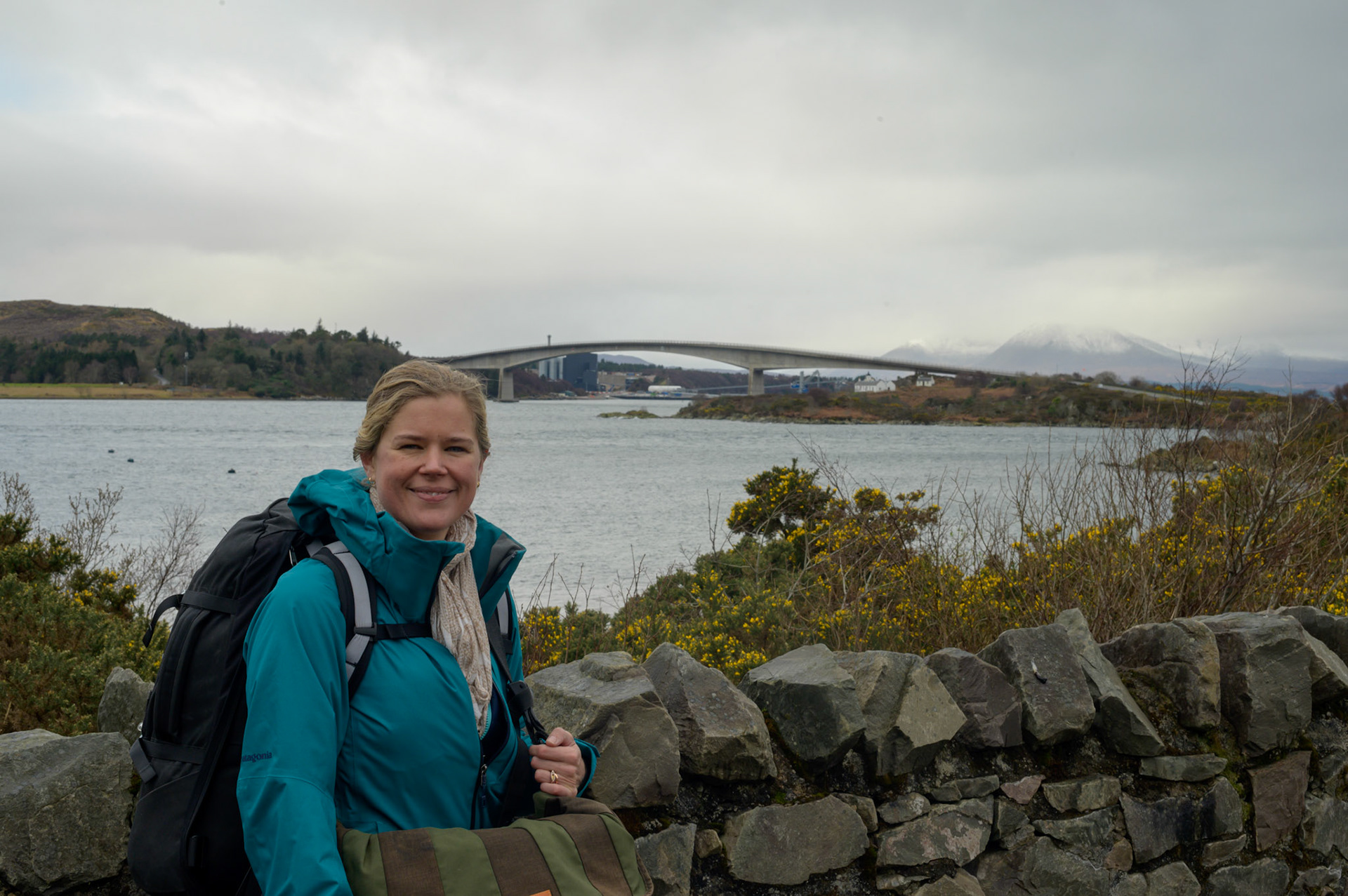 Sheryl with backpack as we walk from Lochalsh to the Kyleakin on Skye. We will cross the bridge in the background. It's not obvious in theis photo, but the wind is howling across the bridge.