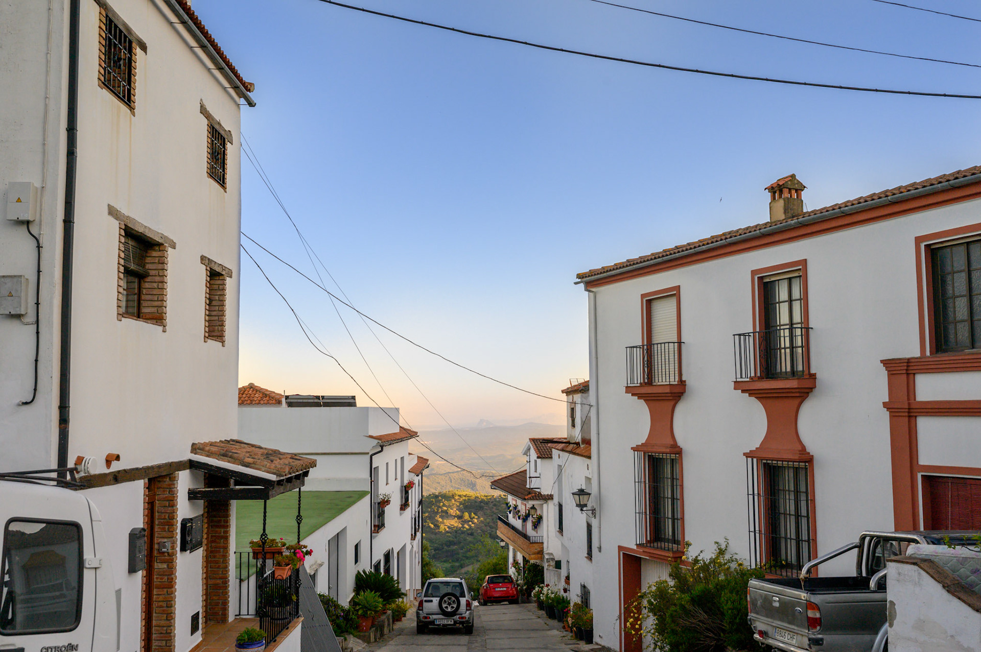 Whitewashed houses crowd hilly streets in Gaucín town, framing vivid blue skies and views to Gibraltar and Morocco.