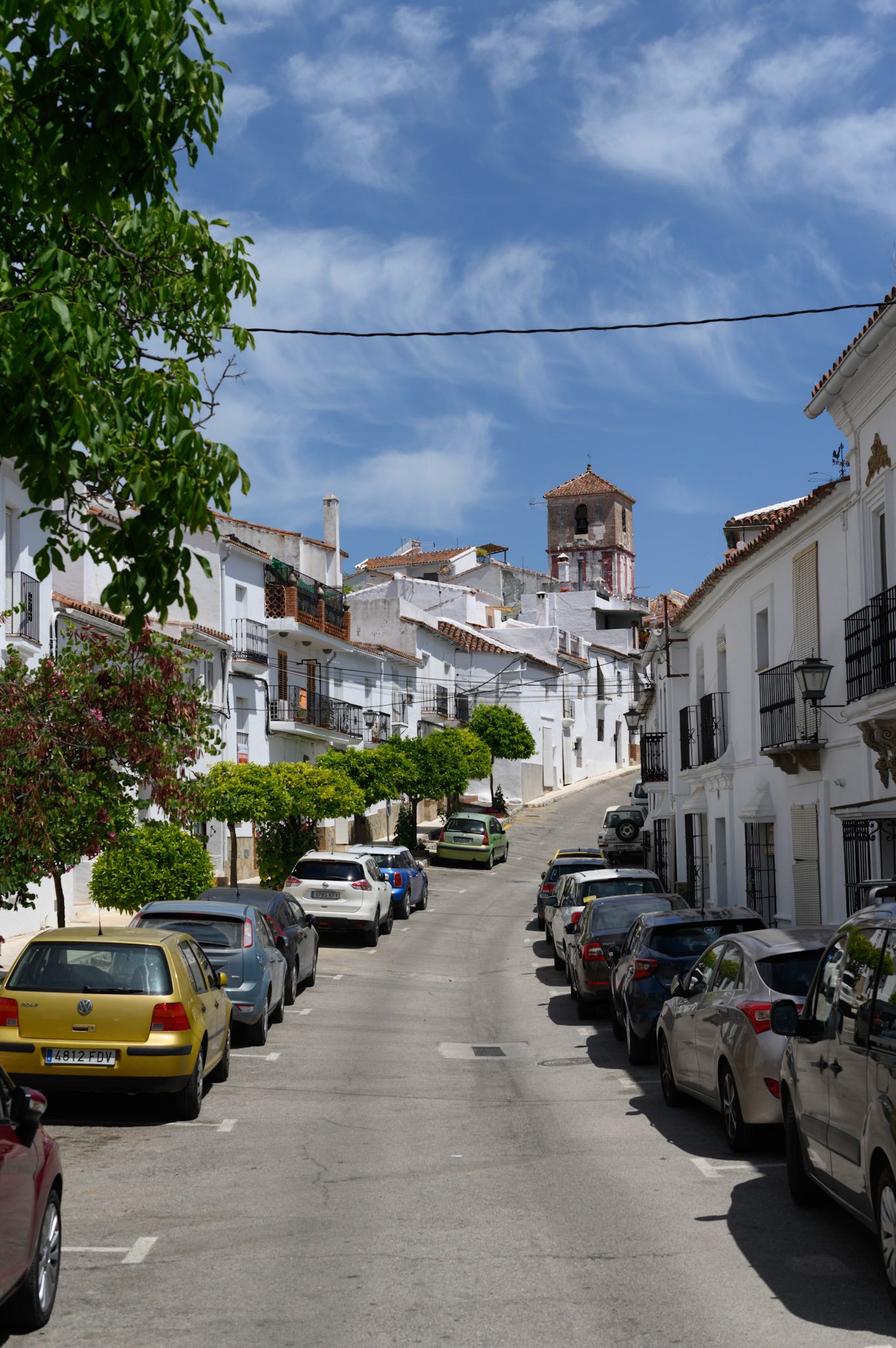 Whitewashed houses crowd hilly streets in Gaucín town, framing vivid blue skies.
