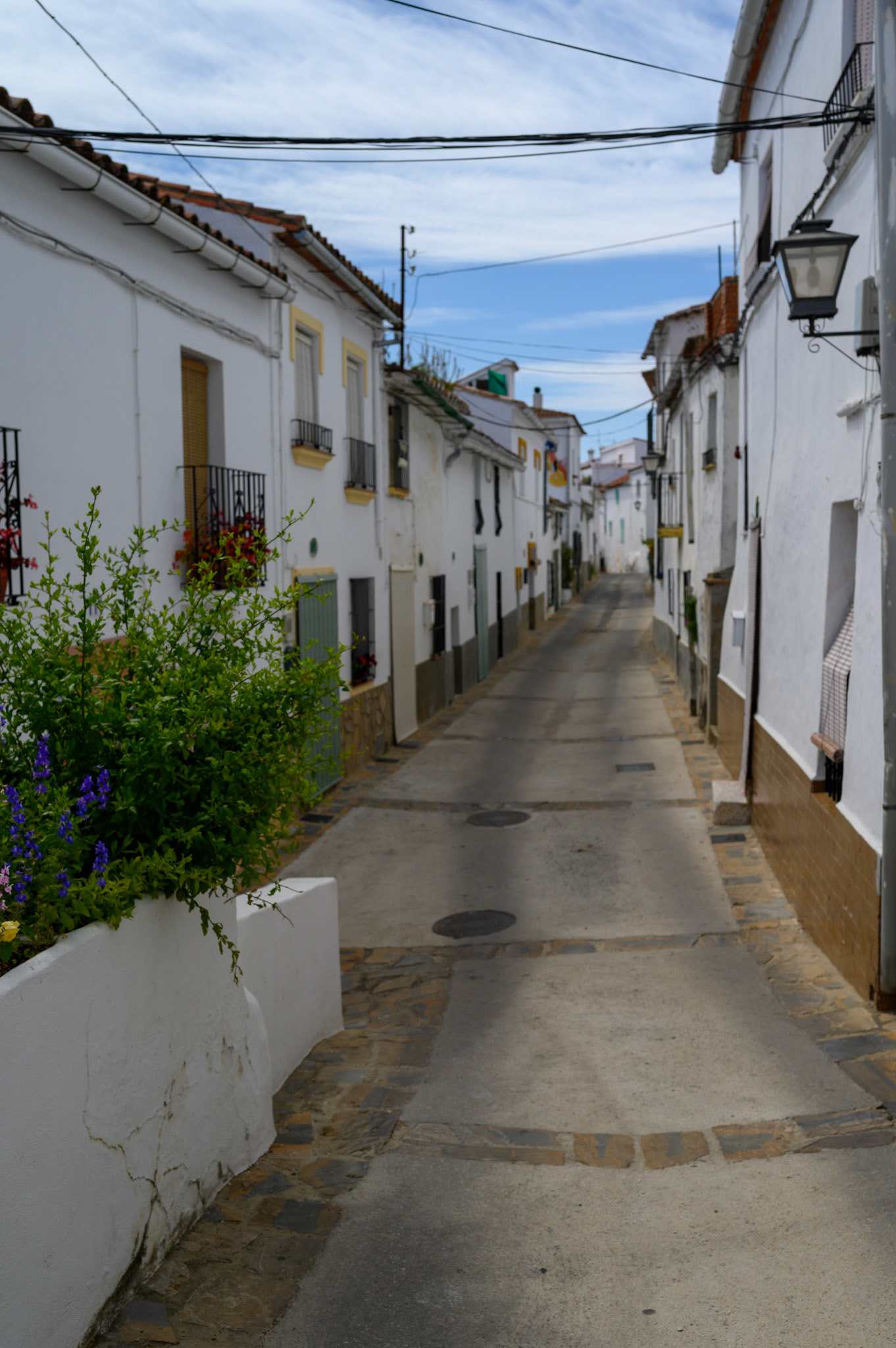 Whitewashed houses crowd hilly streets in Gaucín town, framing vivid blue skies.