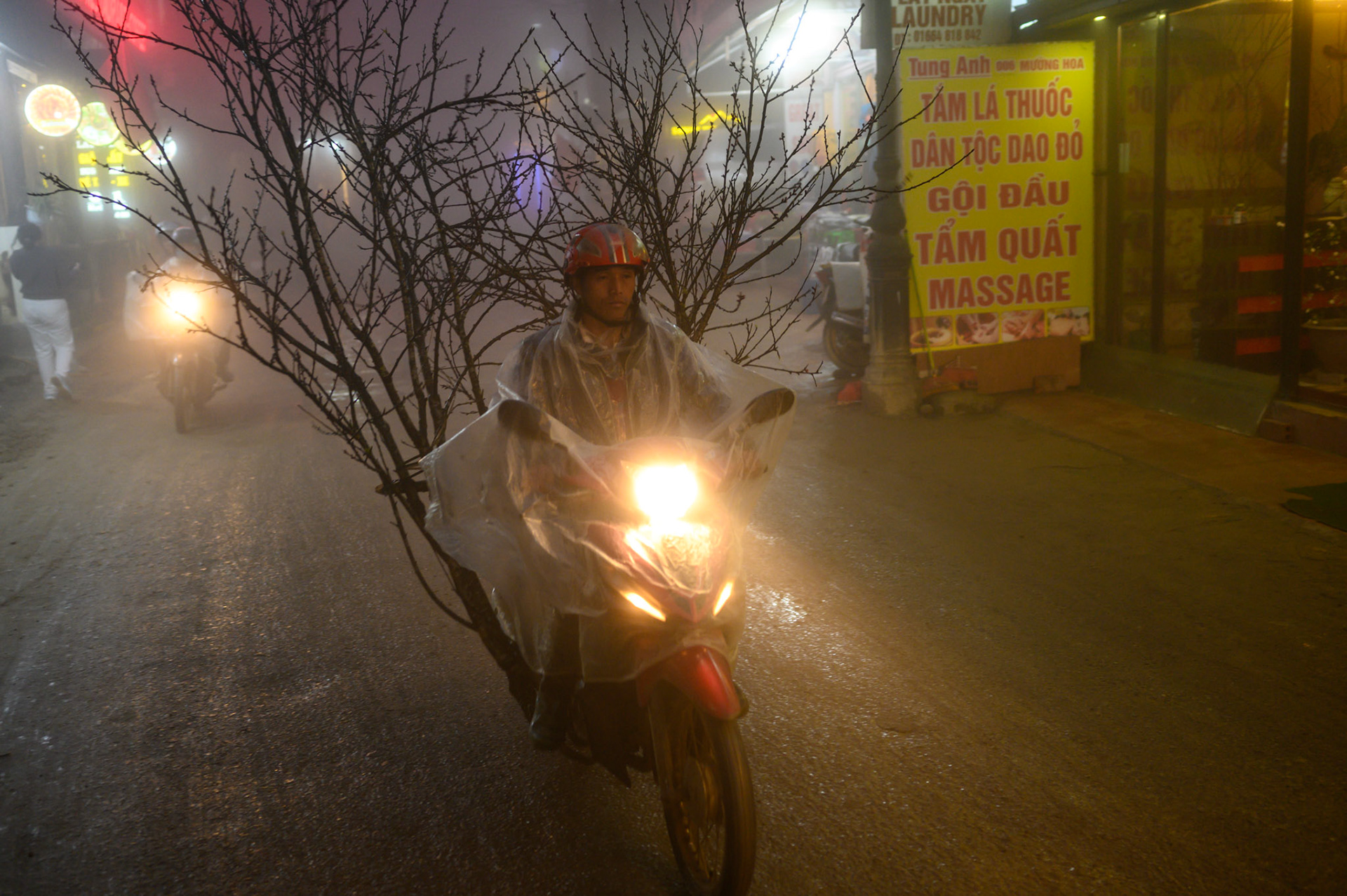A moto rider transports a Tet festival tree through the Sapa mists.
At this time of year Sapa is frequently in clouds, making beautiful neon-lit night scenes.