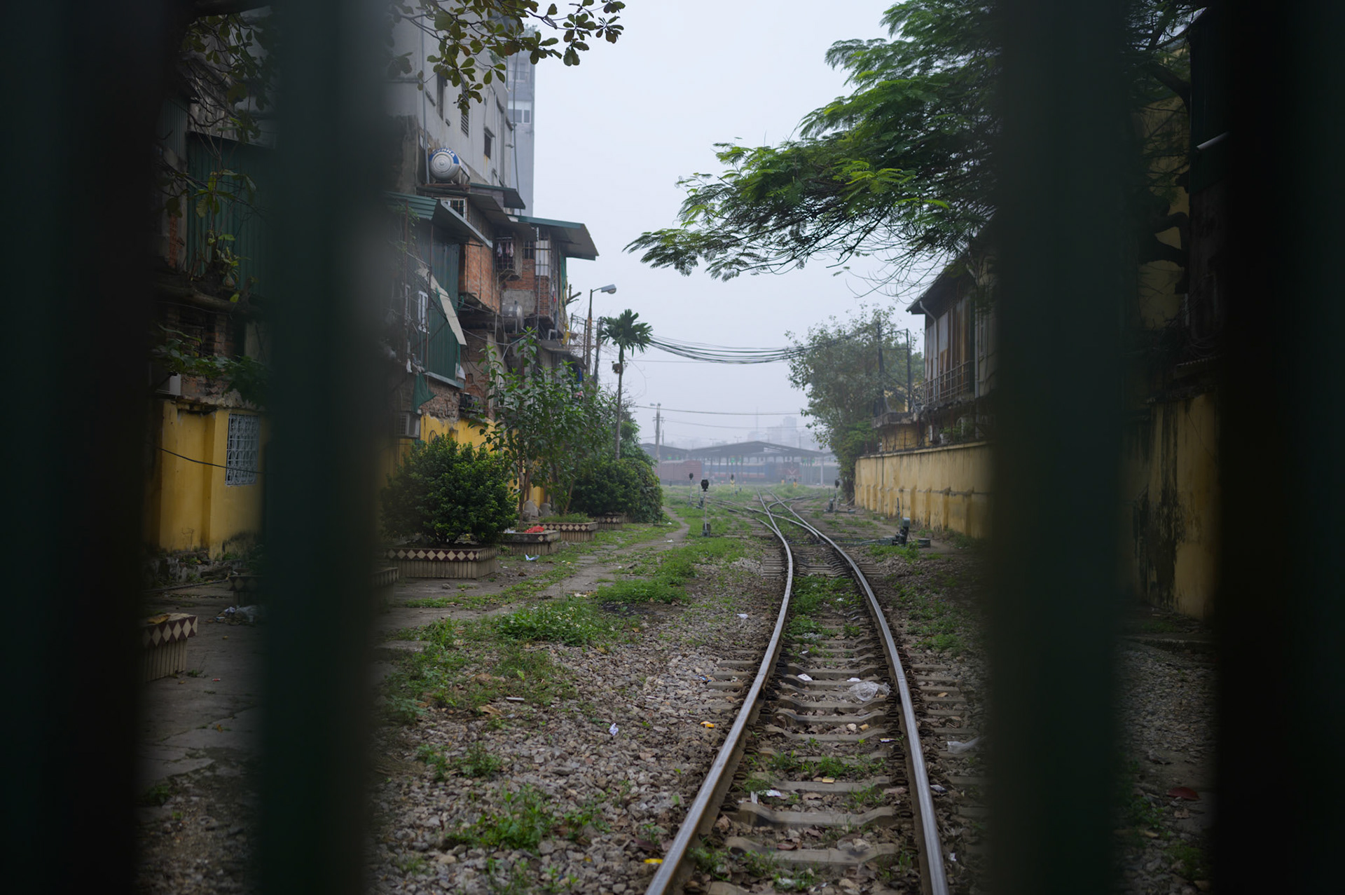 Train tracks behind gates at Ga Ha Noi. The train trains run thorugh the city at night.