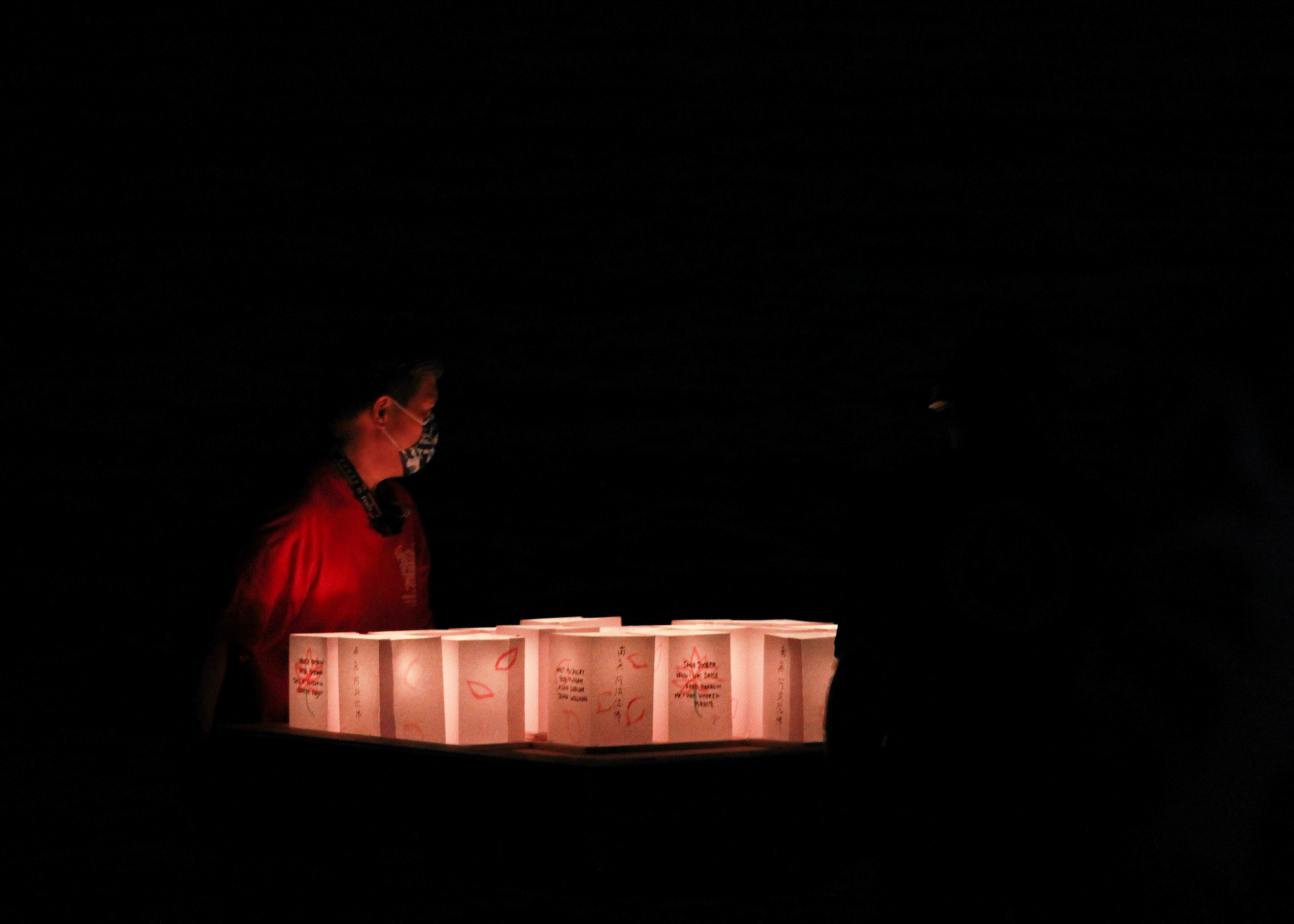 A small barge of lit paper lanterns are carried to the water to be released.