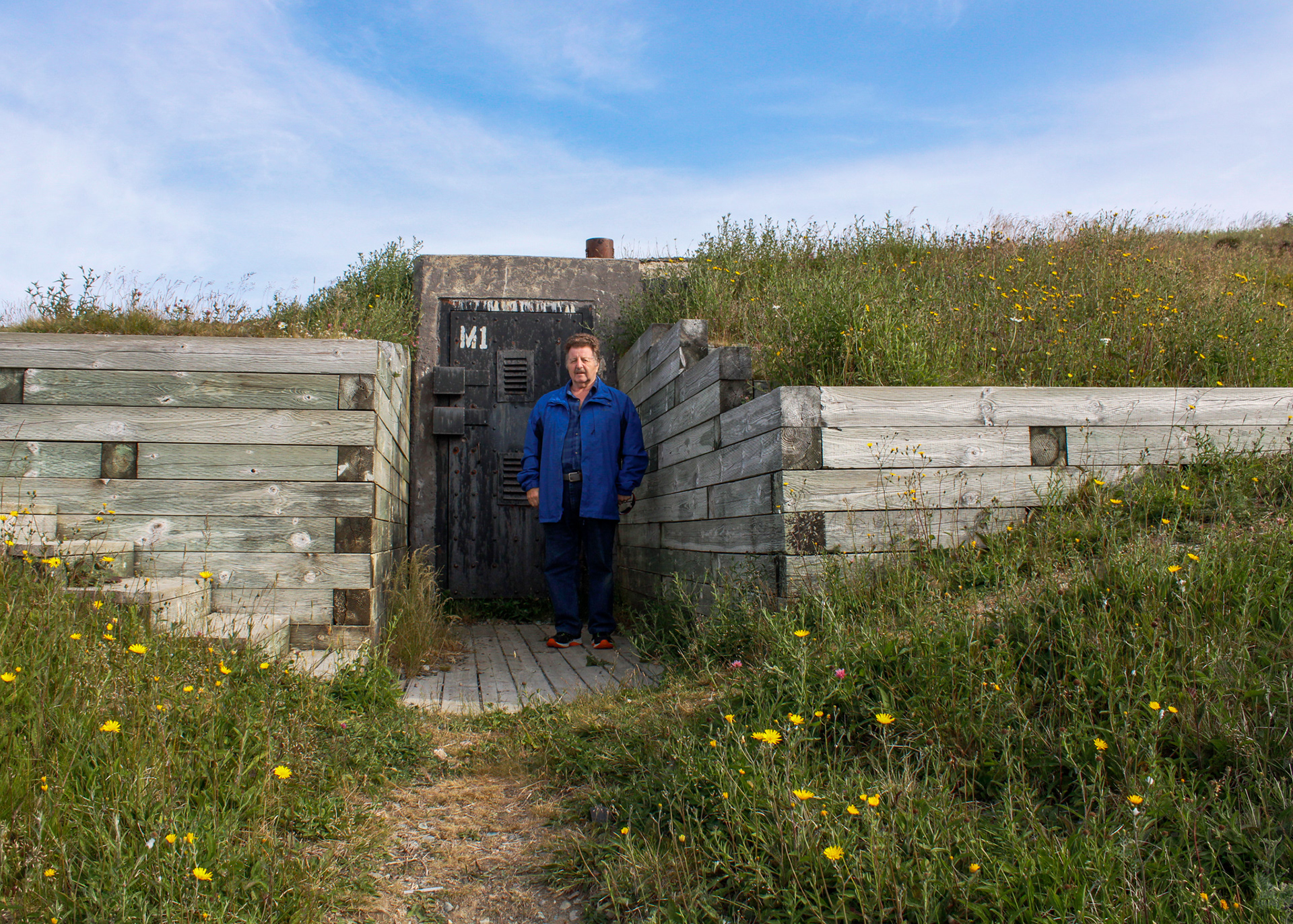Person standing in front of an underground bunker at Signal Hill, Newfoundland, Canada