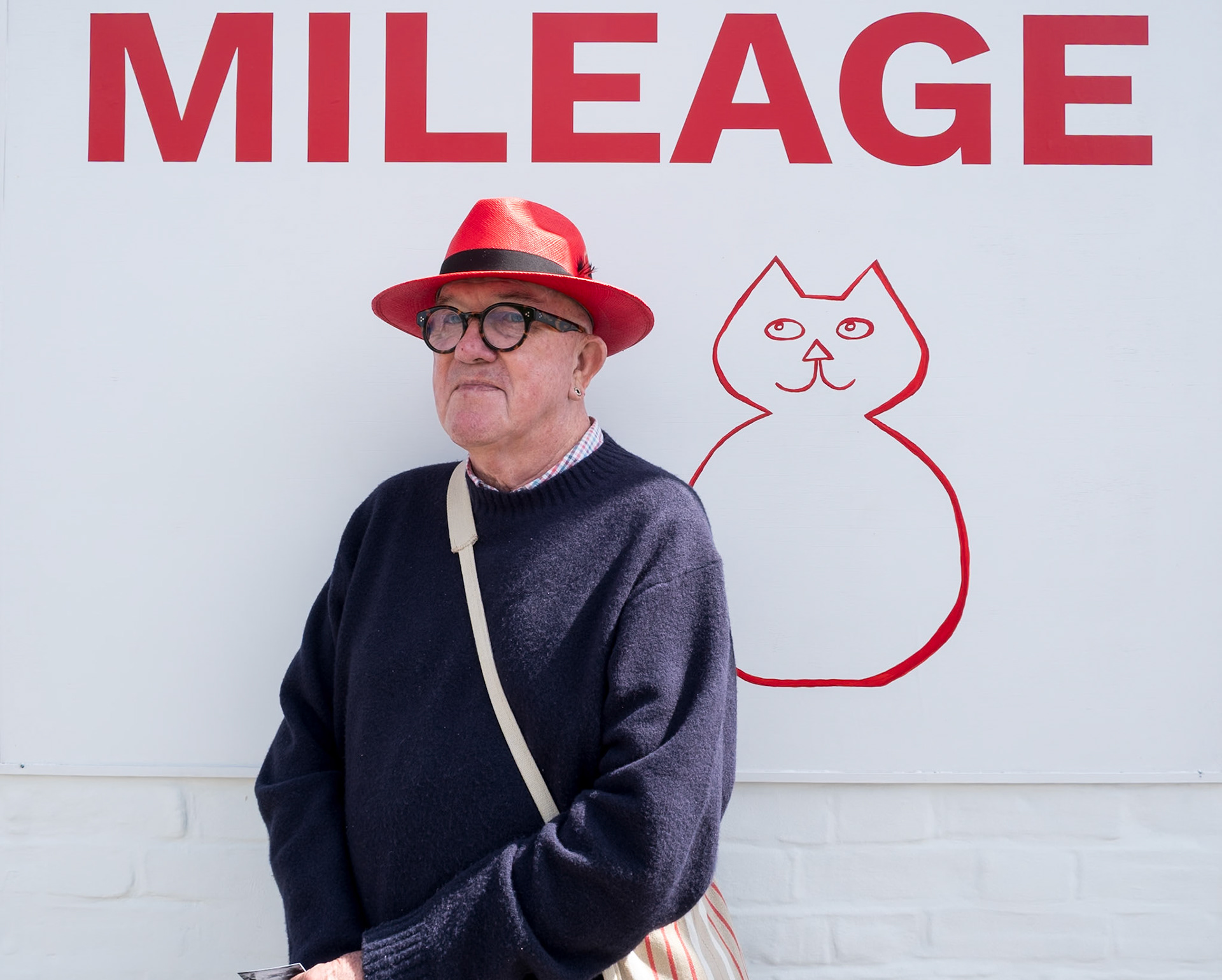 18th April, 2026. I noticed this colourful and stylish gentleman as he walked past the Milage shop sign, Deal High Street, and saw that his red hat matched it perfectly. He introduced himself as ‘Wretched Richard’, and when I asked him what he did for a living he simply said that it was rather complicated. A little research later revealed that it was also hugely impressive. Richard Cawley studied fashion in Paris at the Ecole de la Chambre Syndicale de la Couture Parisienne and life drawing at the École des Beaux-Arts. He was later accepted into the Fashion School of the Royal College of Art in London. He worked at the fashion house of Bellville Sassoon designing clothes for many royal ladies, especially Princess Diana.  Richard went on to write and illustrate many well-known cookery books, including Not Quite Vegetarian and The Artful Cook and countless travel and cookery articles in magazines and national newspapers. Richard also worked extensively in television as a writer-presenter, including Guess Who's Coming to Dinner. He cooked frequently on several cult shows such as Can't Cook, Won't Cook and Ready Steady Cook. He regularly appears in pantomime and has published a novel - The Butterfly Boy. 