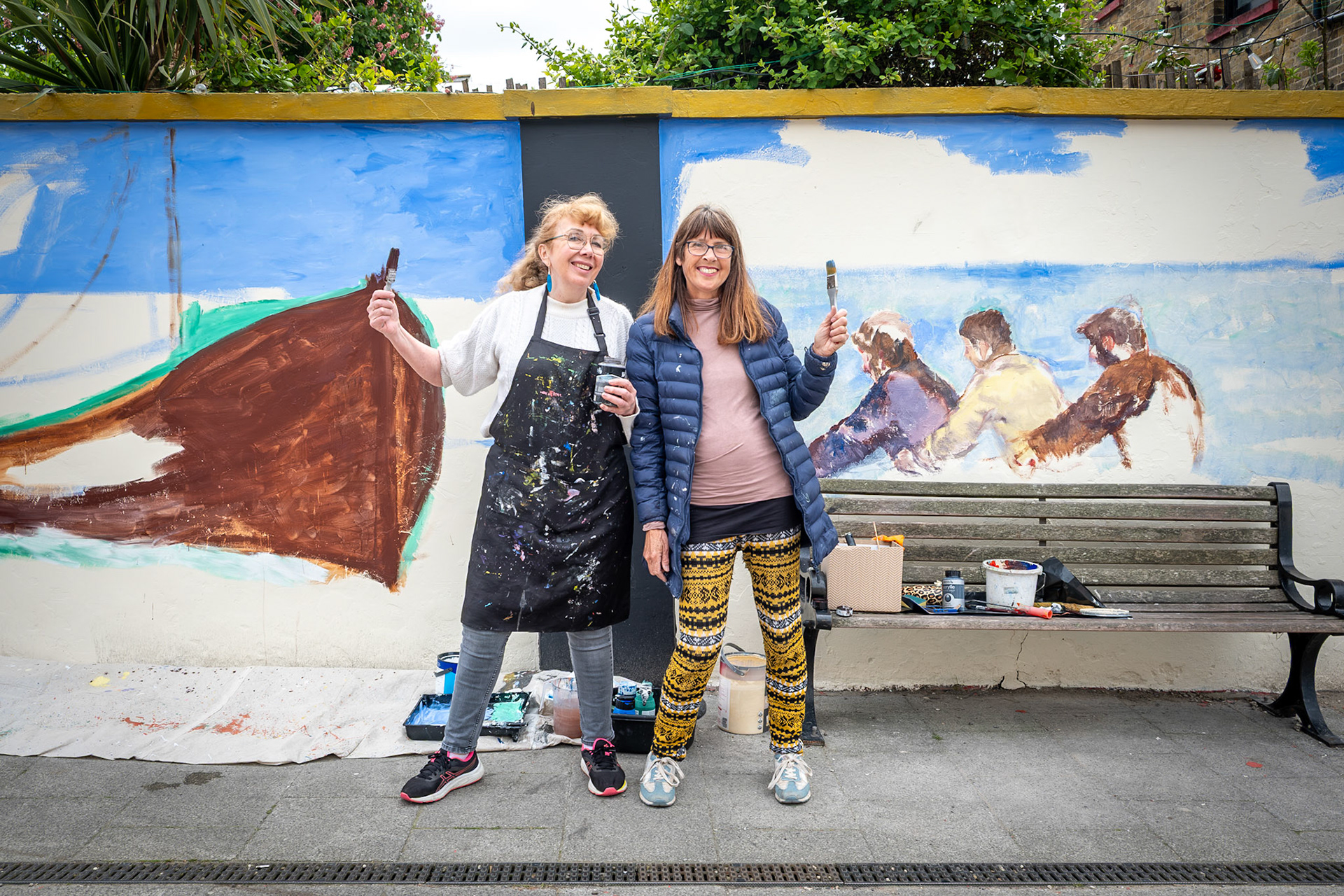 Stephanie Fuller and Penny Bearman painting a new mural on the wall around the beer and music  garden of the Walmer Castle PH, South Street, Deal, as part of Deal Art Streets. 