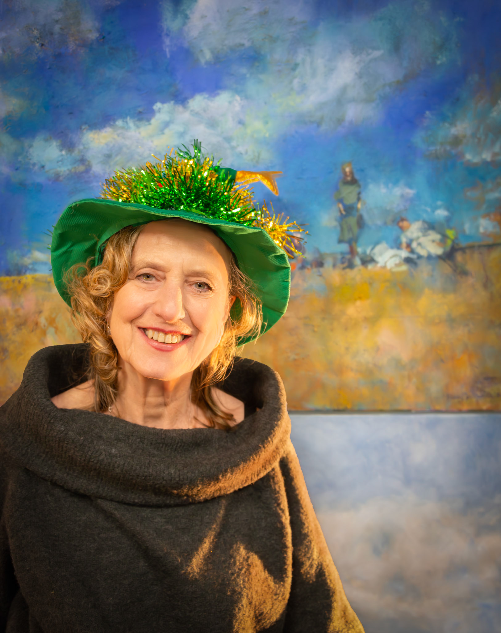 Natalie Cameron-Ward at Penny Bearman's drinks party, Sea Lark Studio, 13th December, 2024. Natalie is an actress, linguist, poet and crazy cold water sea swimmer. The painting behind her is by Penny Bearman and depicts a group of swimmers on Deal Beach. Natalie is the woman standing on the right.