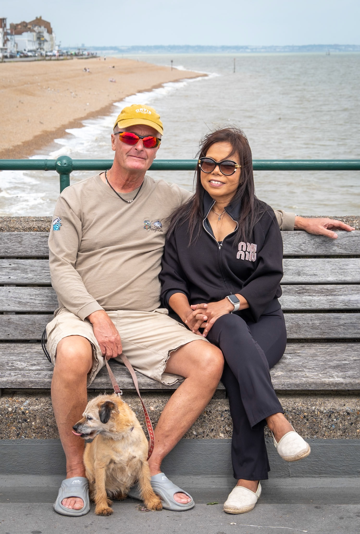 Kevin Stolz and Yammy Blair Buajaroen with their dog Coco. Deal Pier, 18th July, 2026. Kevin is a retired social services manager. Yammy is a masseuse and runs her own business at Yimsmilethaimassage in Deal. 