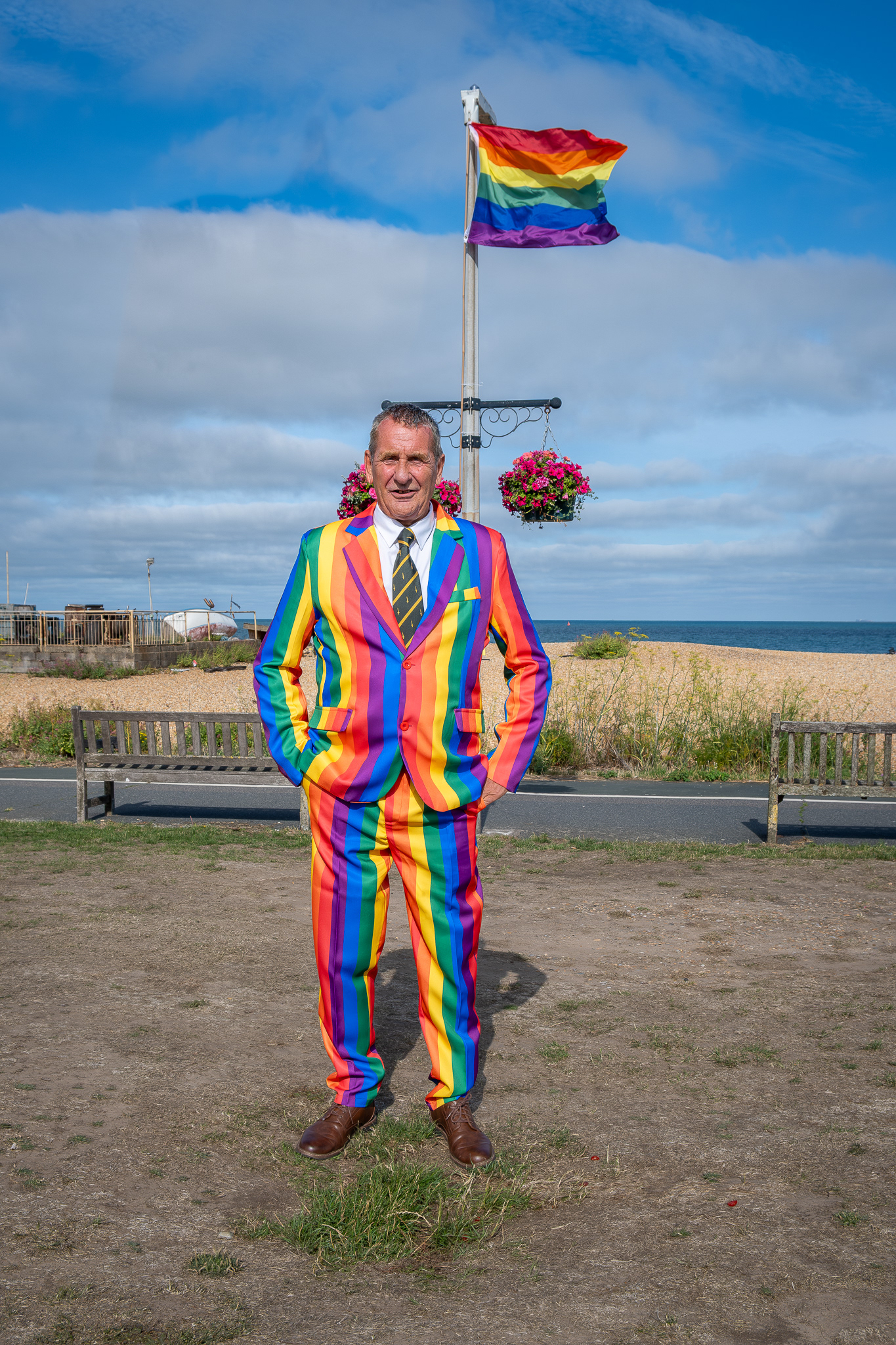 Woody, a former Royal Marine, who I met in the bar at the Royal Marines Association, 12th July, 2025. He was wearing such an strikingly gay suit I asked him if I could photograph him on Walmer Green against the backdrop of the Deal Pride Party. Strangely, this photo is not part of either the Deal Pride or the Marines Association collections.