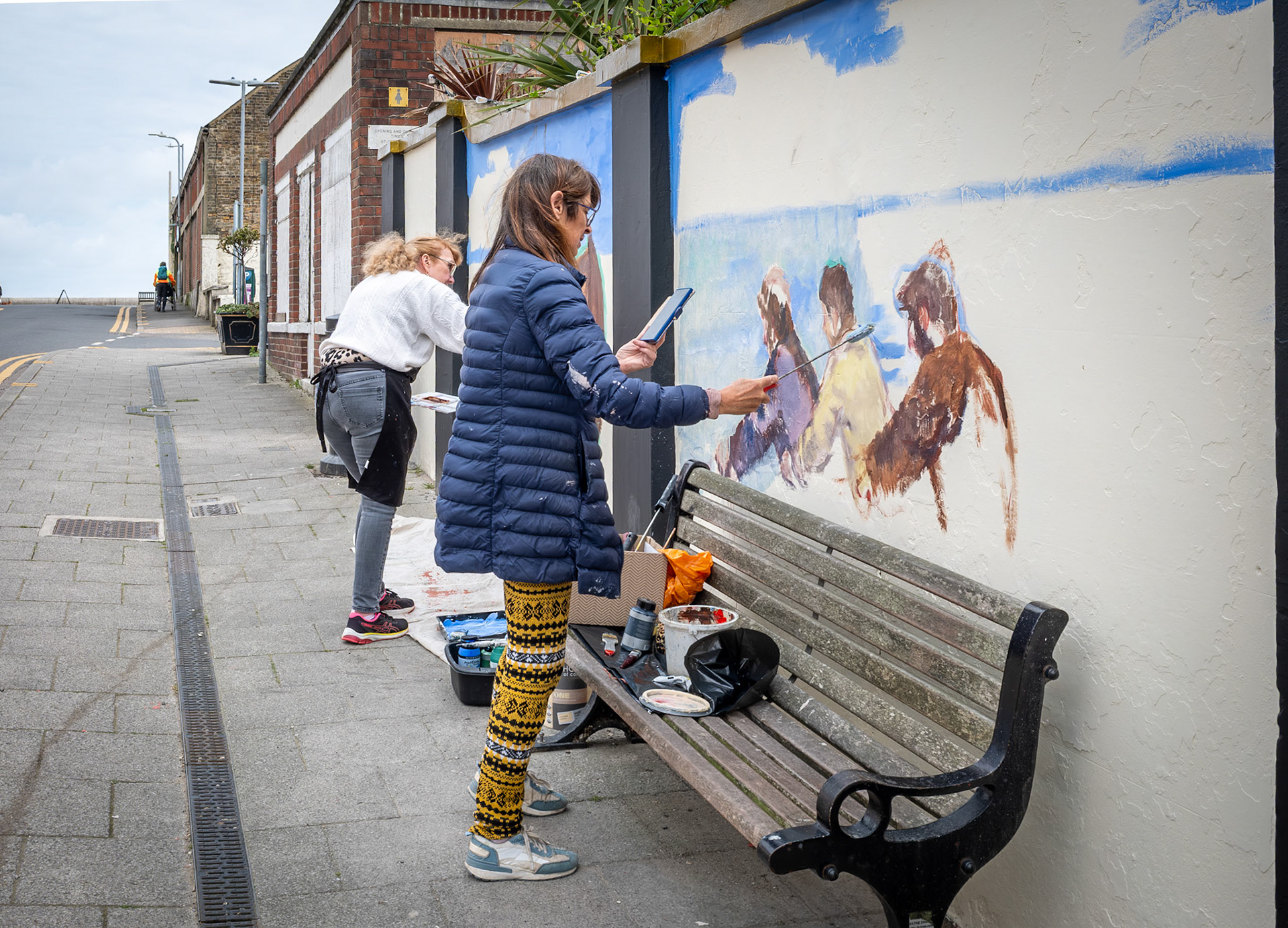 Stephanie Fuller and Penny Bearman painting a new mural on the wall around the beer and music  garden of the Walmer Castle PH, South Street, Deal, as part of Deal Art Streets. 