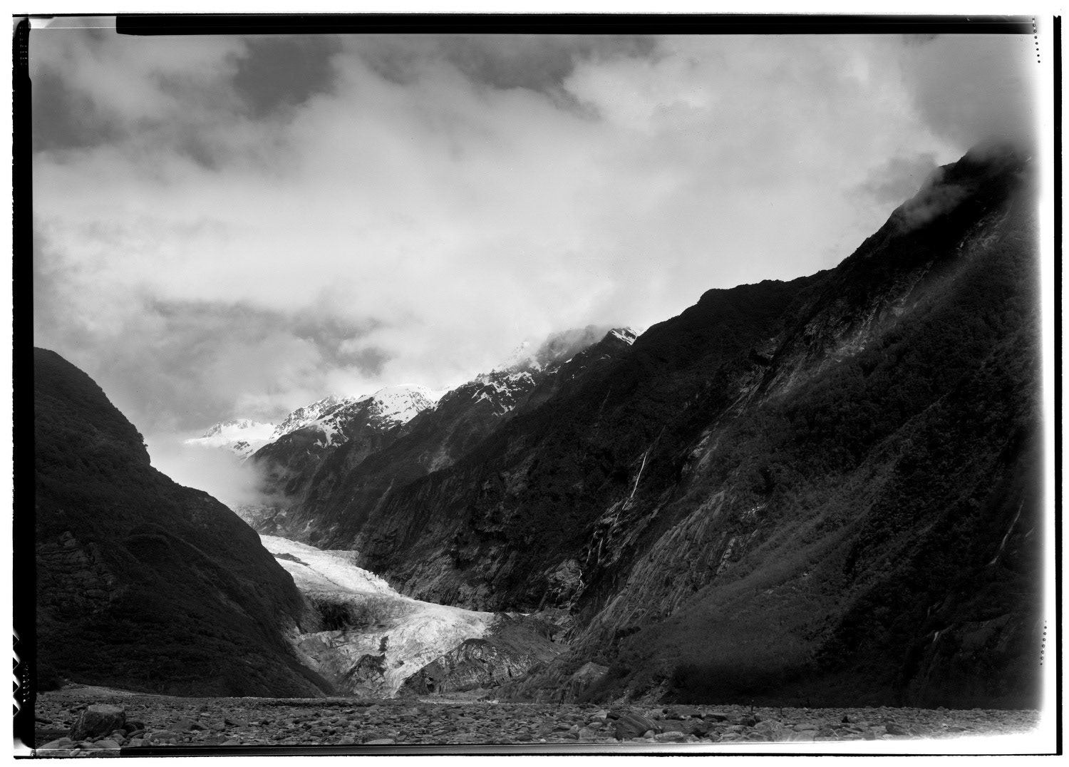 Cliffs emerge from the clouds at the Franz Josef Glacier in the Westland National Park in the Southern Alps of New Zealand.