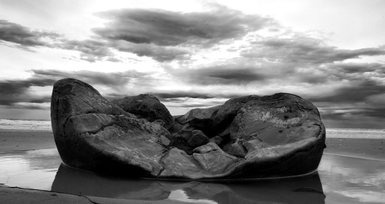 An eroded Moeraki Boulder lies exposed on the beach on the south island of New Zealand.