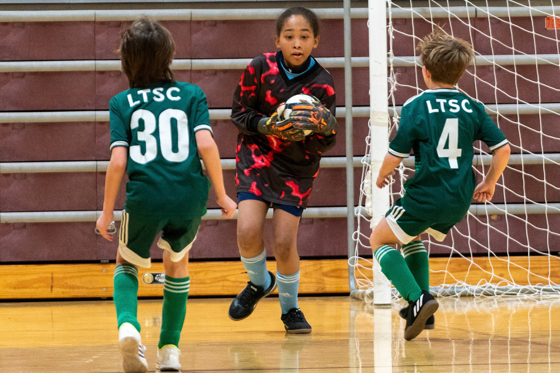 Drake scoops up a shot as two attackers descend on him as MWFC defeats LTSC 8-2 on Saturday, February 4, 2023.