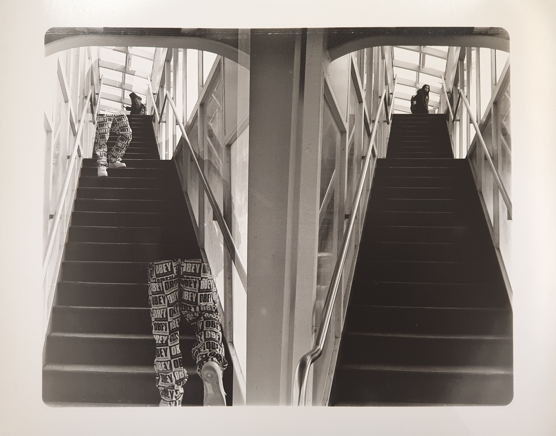 Two black and white side-by-side photographs of a stairway. The left side has a partially invisible figure at two different points of the stairs.