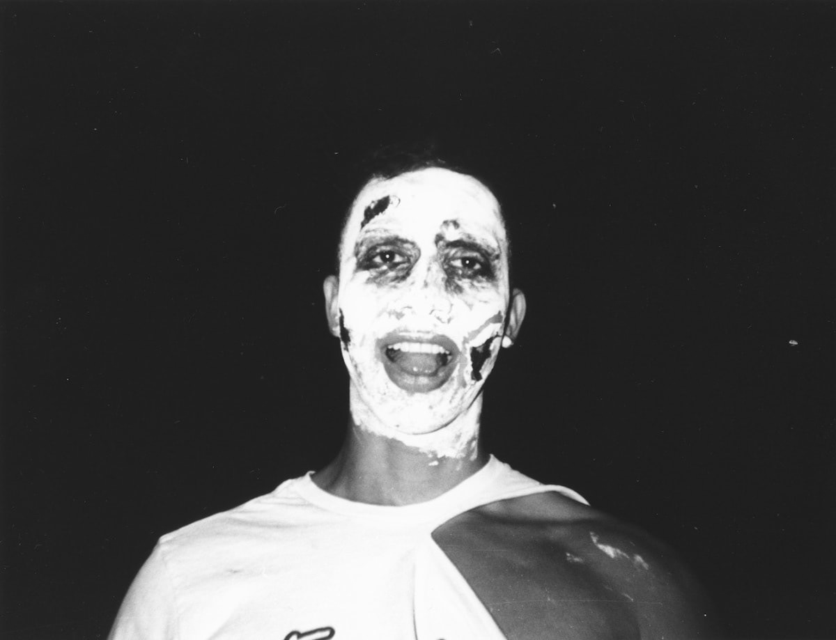 Black and white photo of a man with white paint on his face