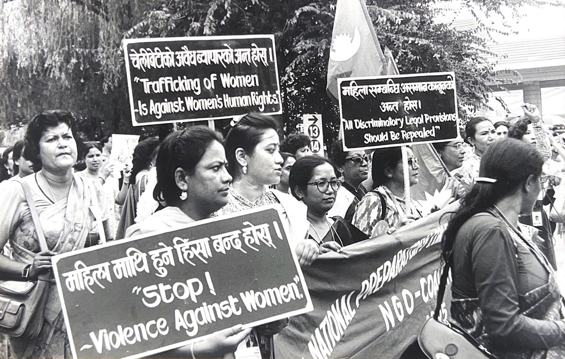 Black and white photograph of women marching in a protest with signs promoting the protection of women's rights