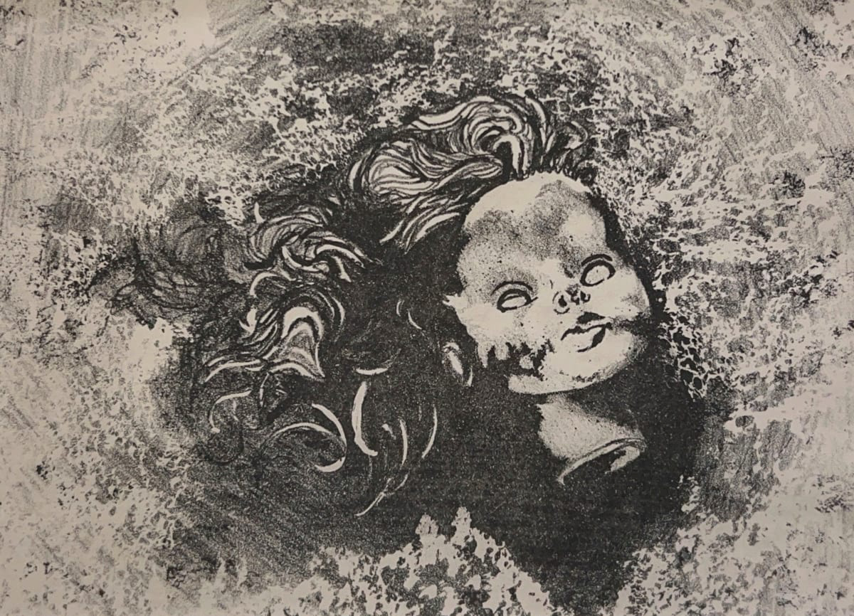 Doll head lying on the ground with fanned out hair. Smudges and lines surround the doll head, decreasing in density farther out from the head. The image is made from black and beige tones