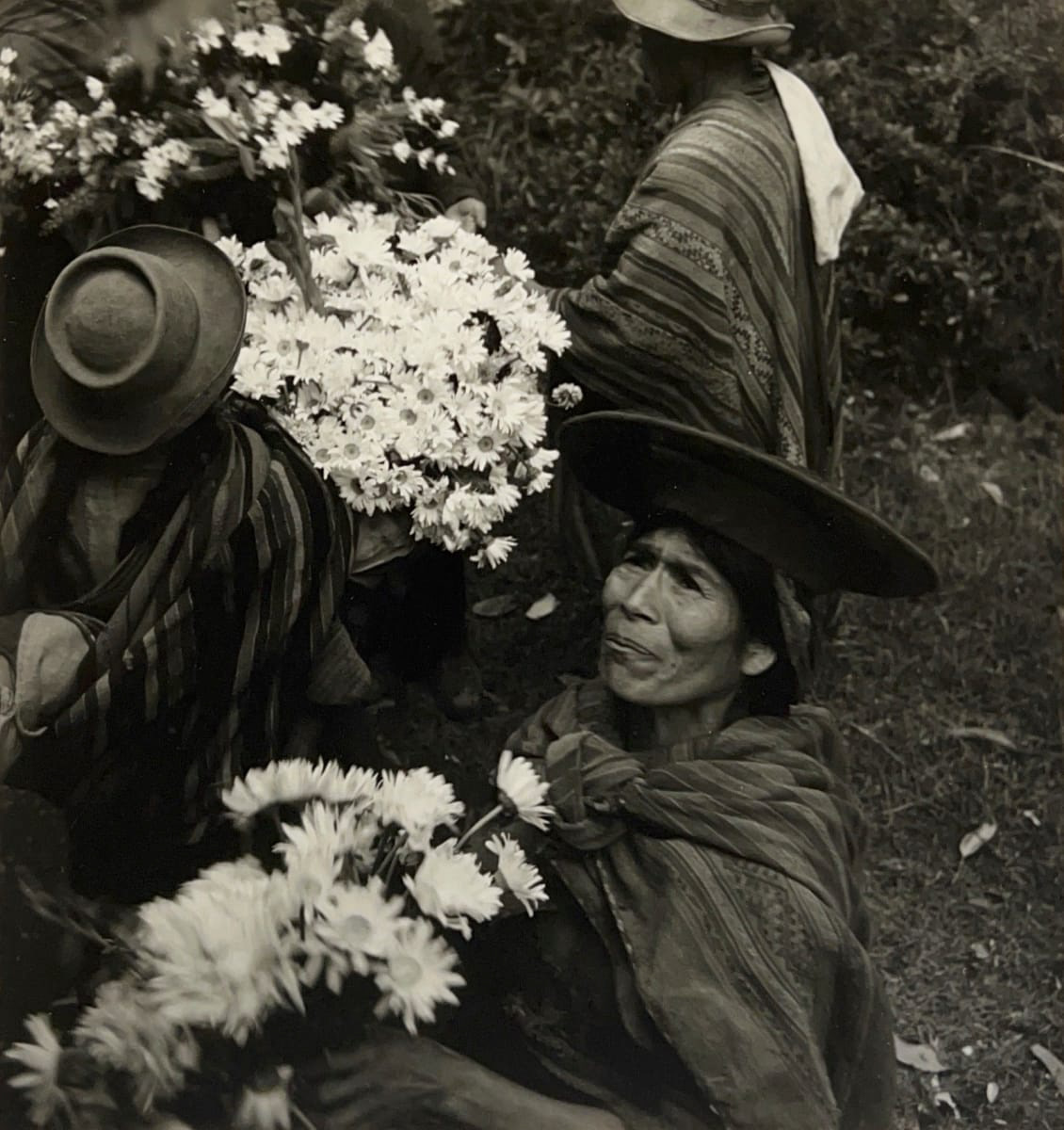 Black and white photograph of a woman selling flowers