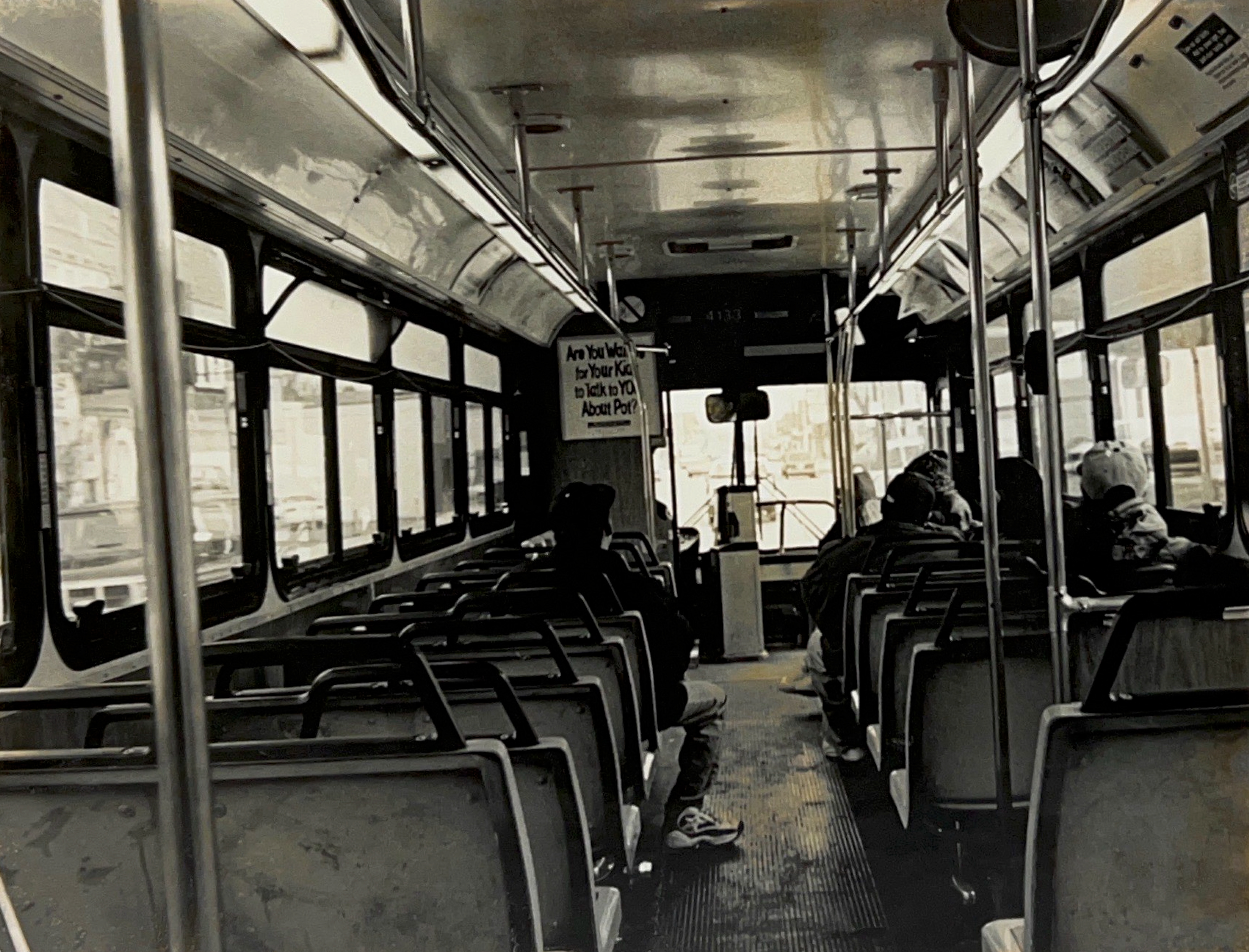 Black and white photograph of the view from the back of a bus