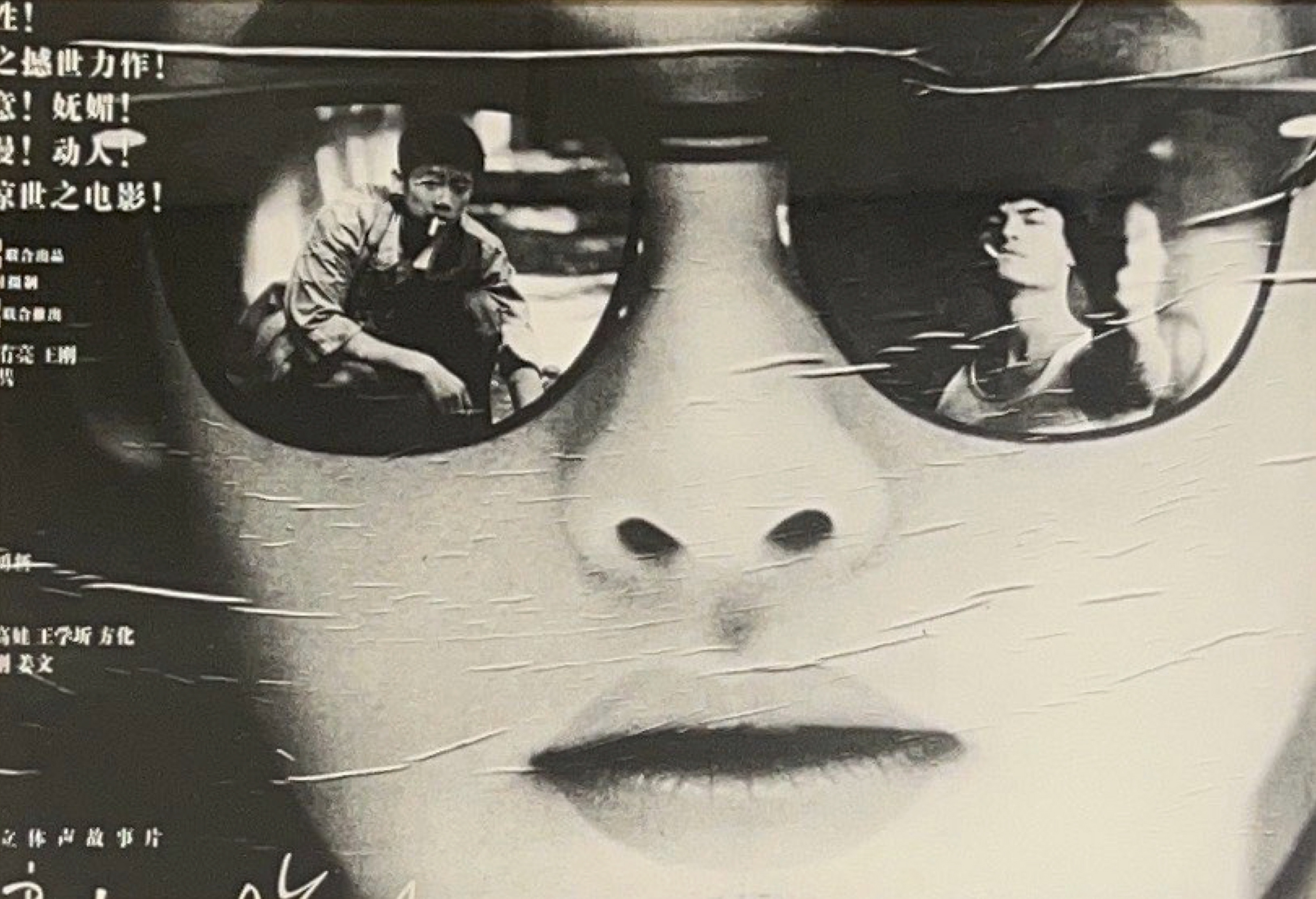 Black and white photograph of a woman's face wearing sunglasses with the reflections of men in each lens.