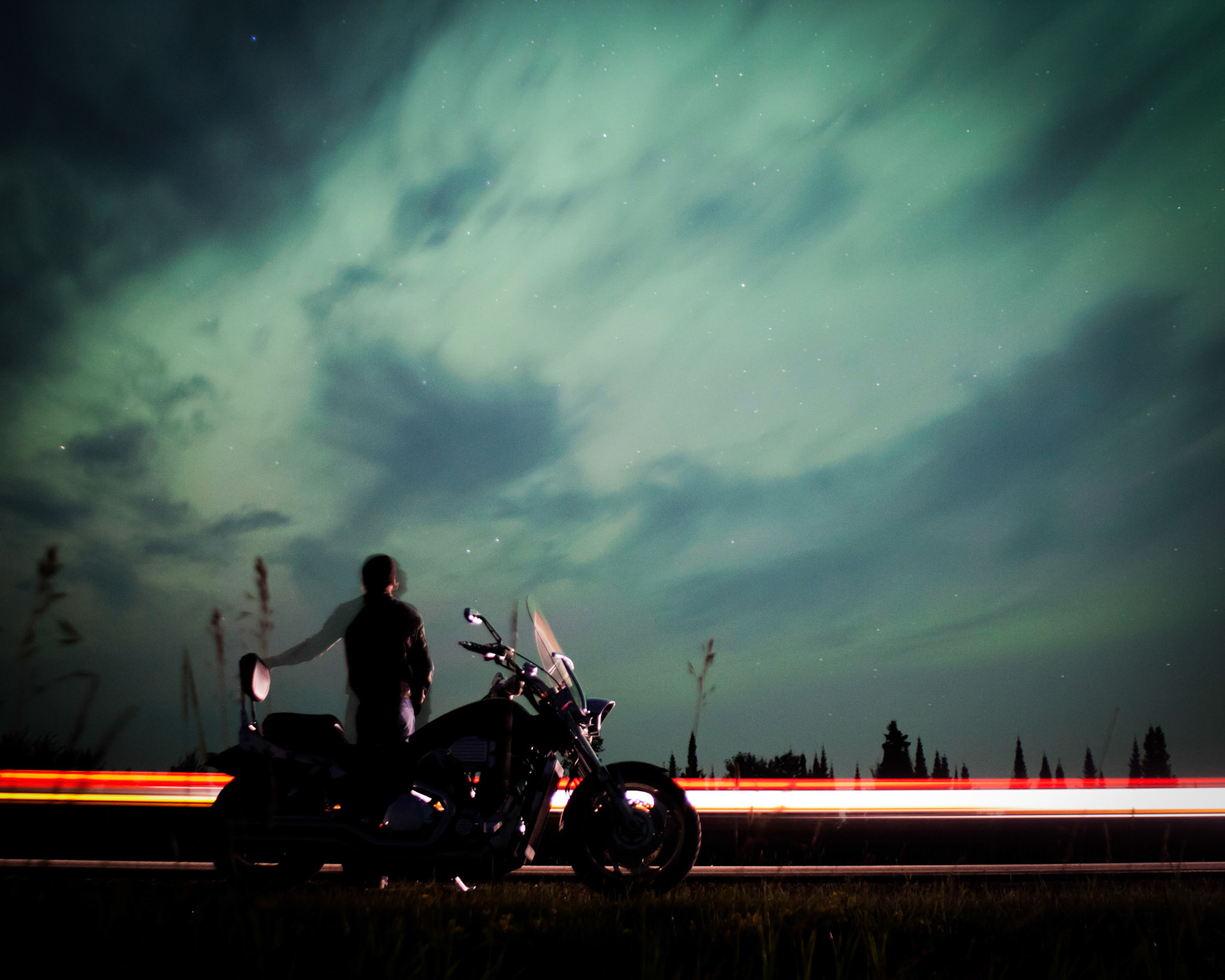 A Motorcyclist stops on the roadside to view the Aurora Borealis; or Northern Lights, near Blackduck, MN during the early morning hours of July 15 2012. These aurora displays were part of a moderate (G2) Geomagnetic Storm. Such storms can disrupt power grids and interfere with GPS signals and other satellite operations.This storm is the result of an X-1.4 solar flare launched from a sunspot on the 12th of July.