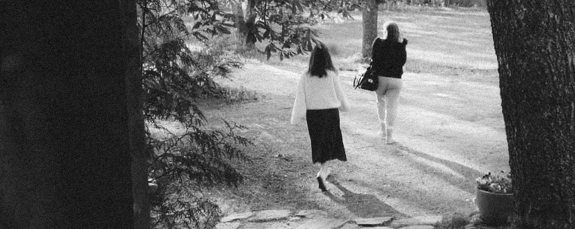 Photographer Peppi Laine and model walking away from camera in black and white photo