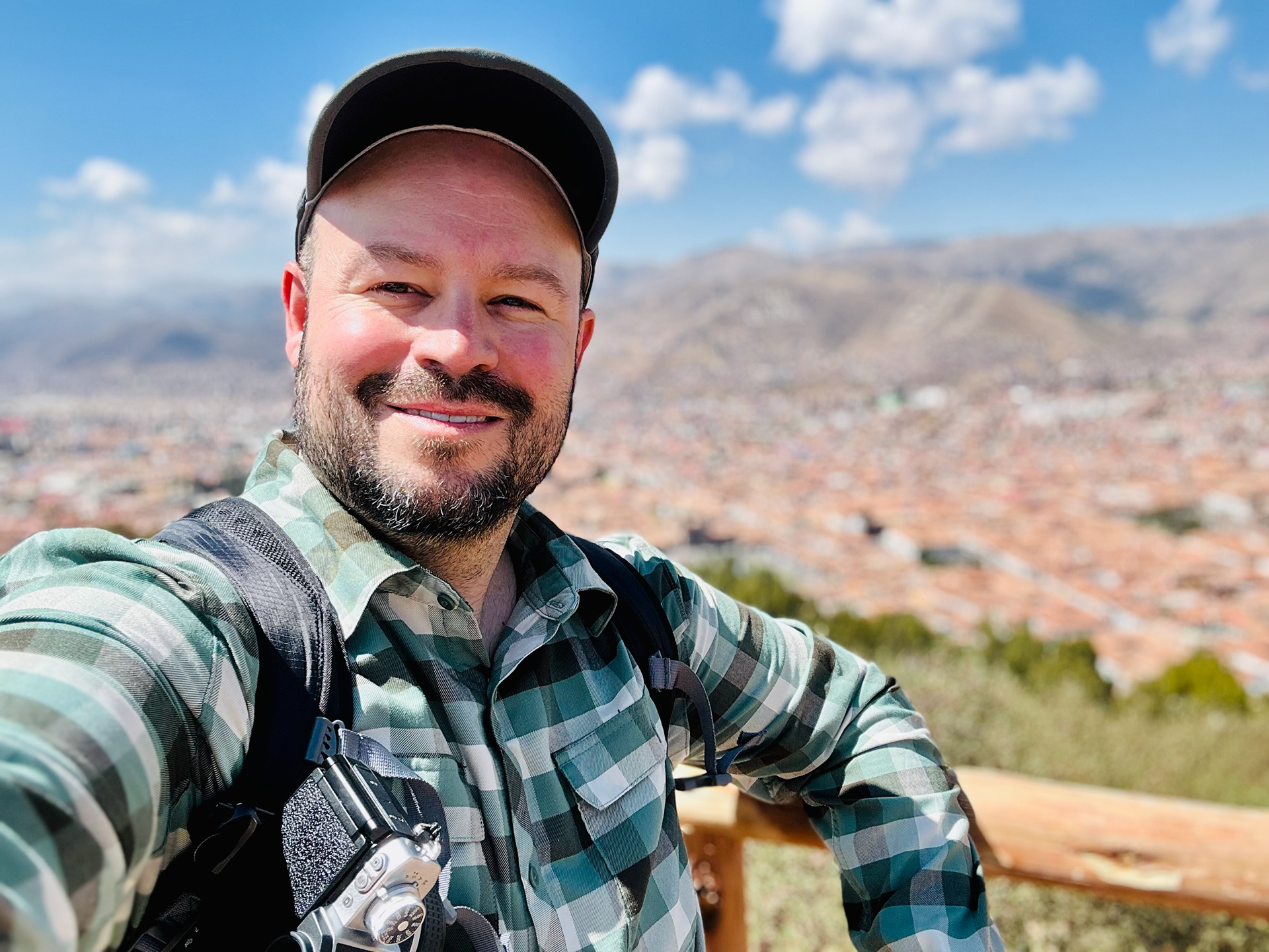 Photo of Brian standing in front of scenic mountains overlooking Cusco, Peru