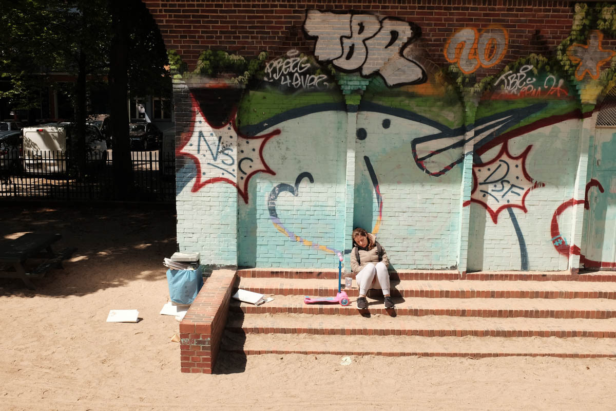 A mother rests in the midday sun. Berlin, May 2022