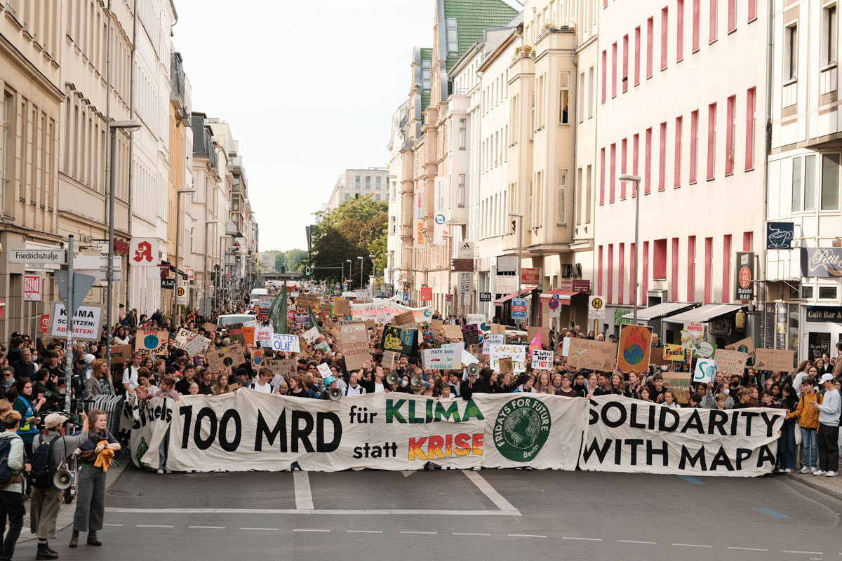 Protesters demand a 100 Billion Euro German climate fund - equal to that what has been committed to the German military in 2022.