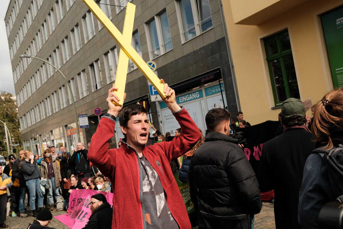 An activist holds a yellow "X" symbolising the opposition to atomic energy.