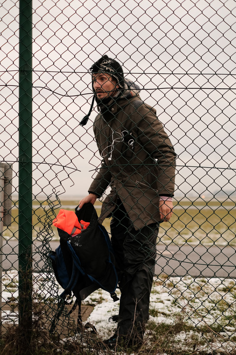 Raúl Semmler cuts through a fence to gain entry to Berlin Airport
