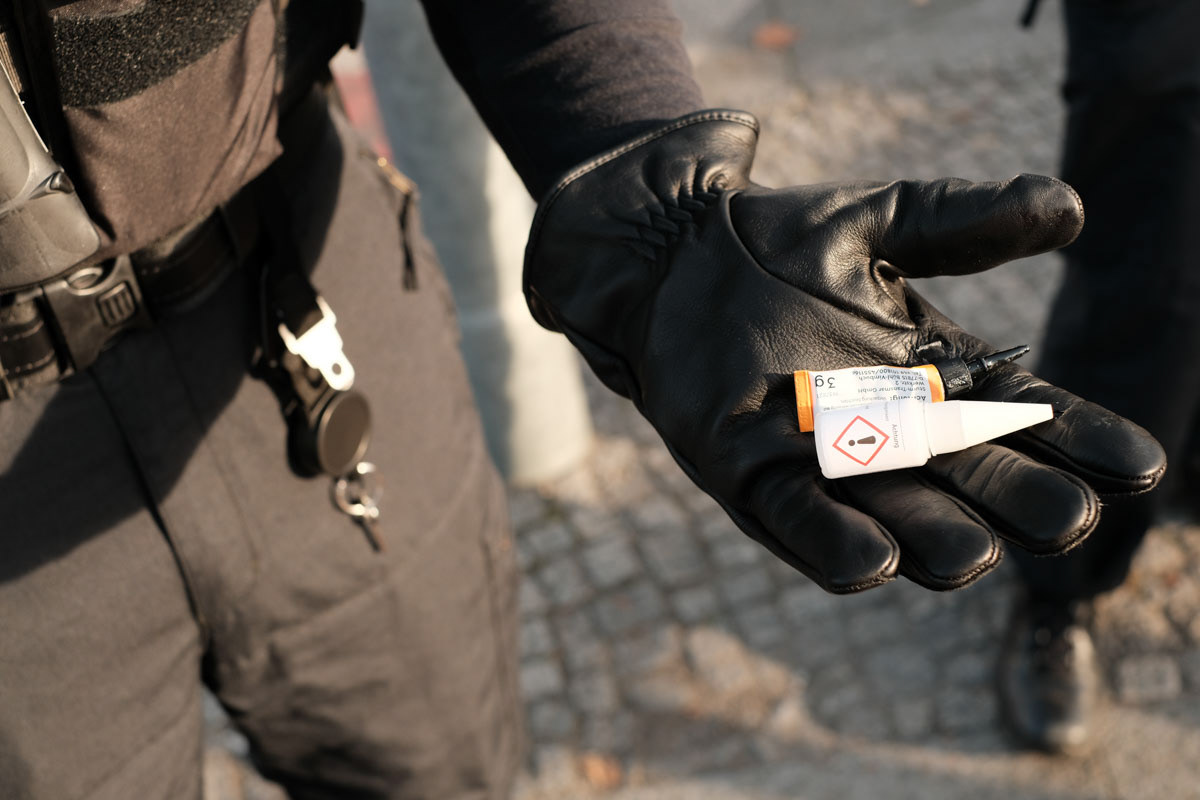 A police officer holds glue that was confiscated from activists
