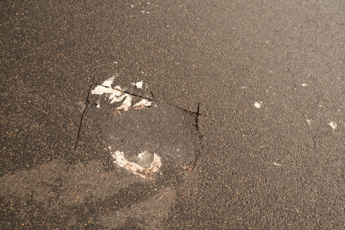 Police cut an activists hand from the street after hours of attempting to remove glue and silicon.