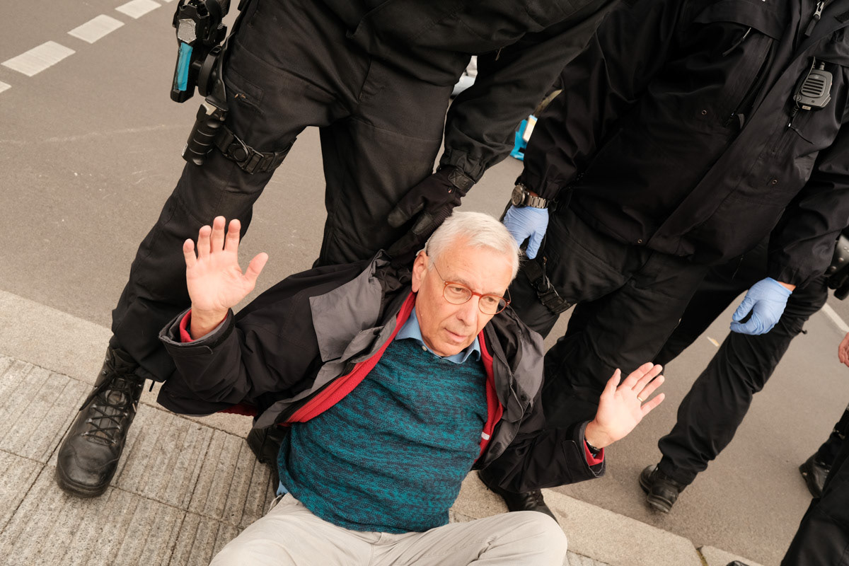 Police prevent an activist from joining a protest.