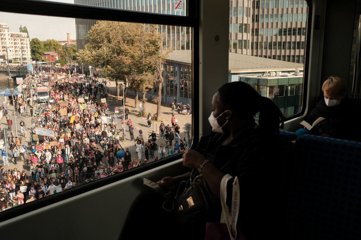 U-Bahn passengers watch as a protest passes under them.
