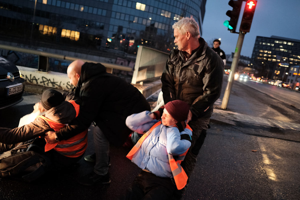 Activists are dragged from the road by motorists