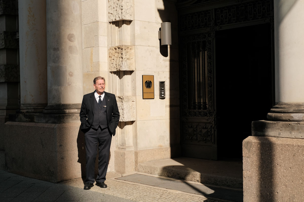 An employee from the German parliament "Deutsche Bundestag" watches as hoards of protesters approach their building.