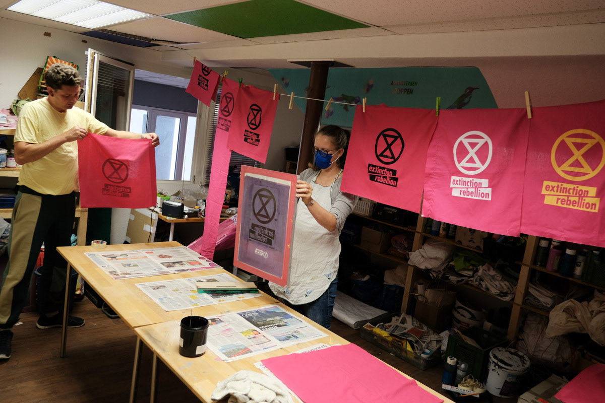 Extinction Rebellion screen prints flags. The group is known for a visually powerful protest style.