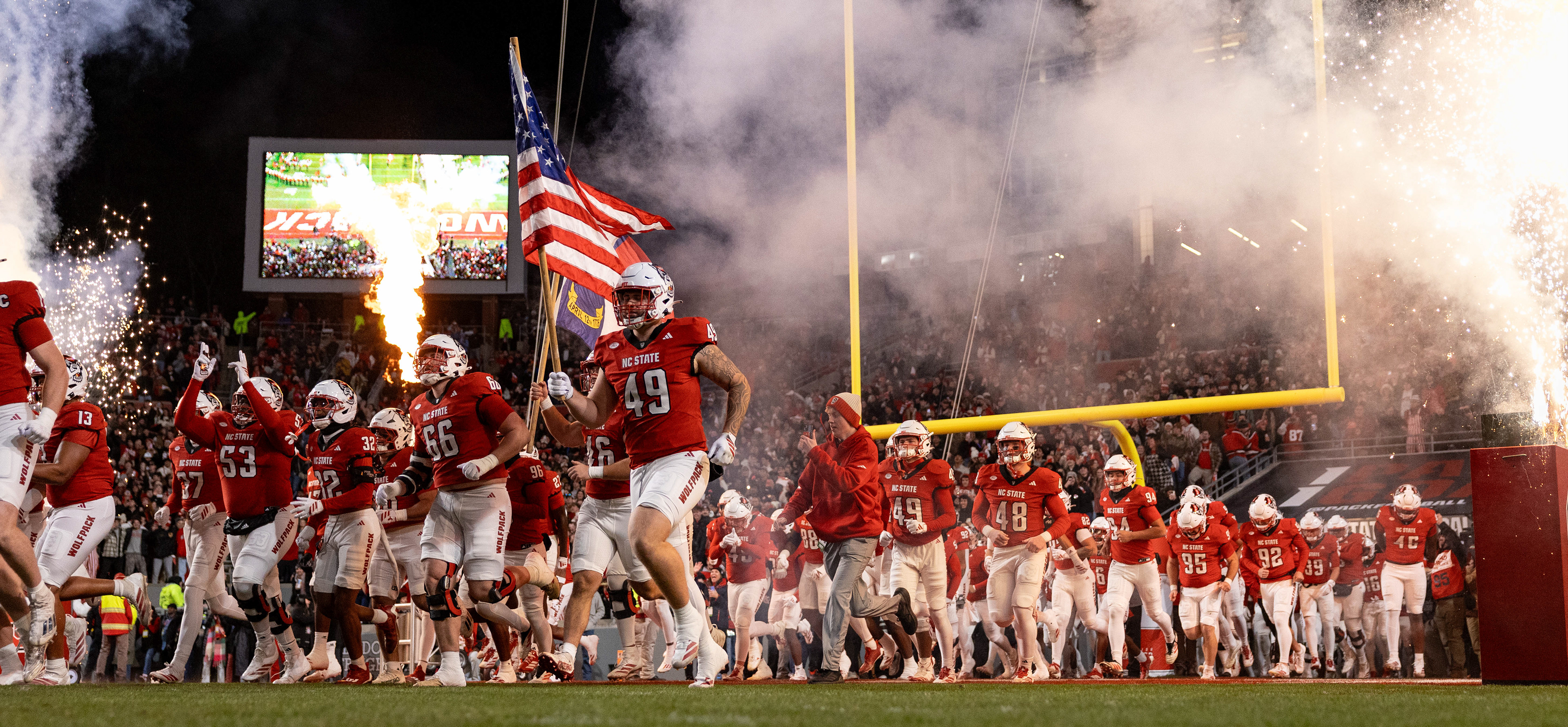 N.C. State football players run out onto the field prior to the game against UNC at Carter-Finley Stadium on Saturday, Nov. 29, 2025.