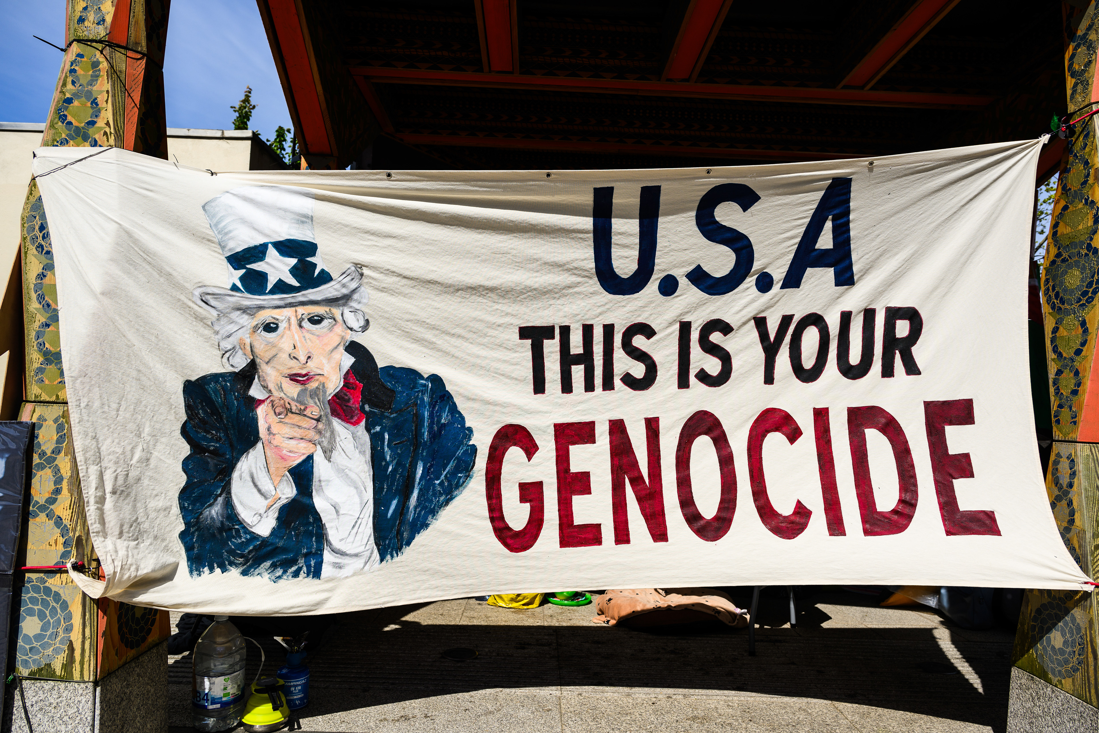 This poster is a permanent installation at the protest camp and points directly towards the US Embassy in London.