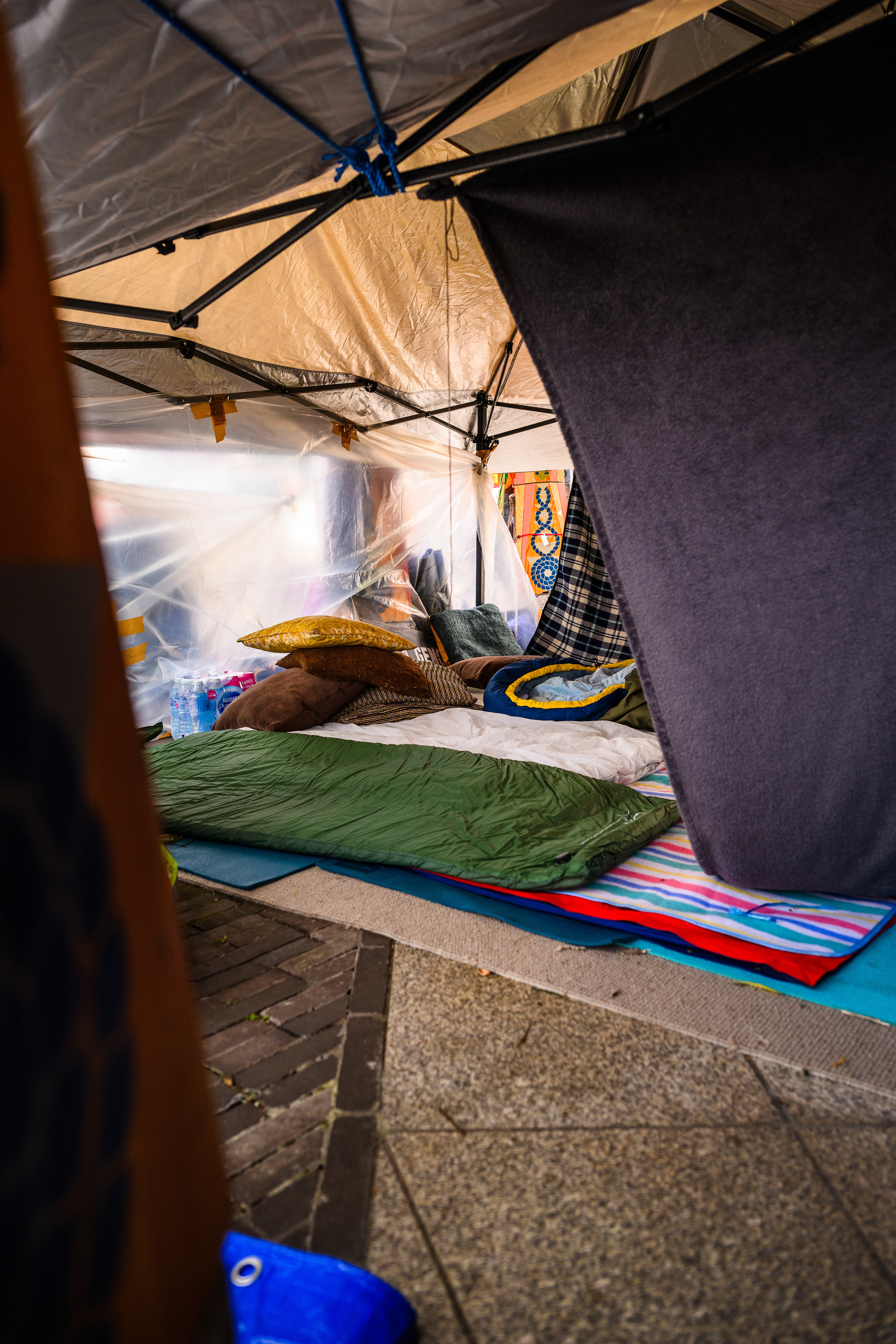 The sleeping area is a tent with some floors mats and sleeping bags. Protesters stay here at night to keep the camp safe outside the US Embassy